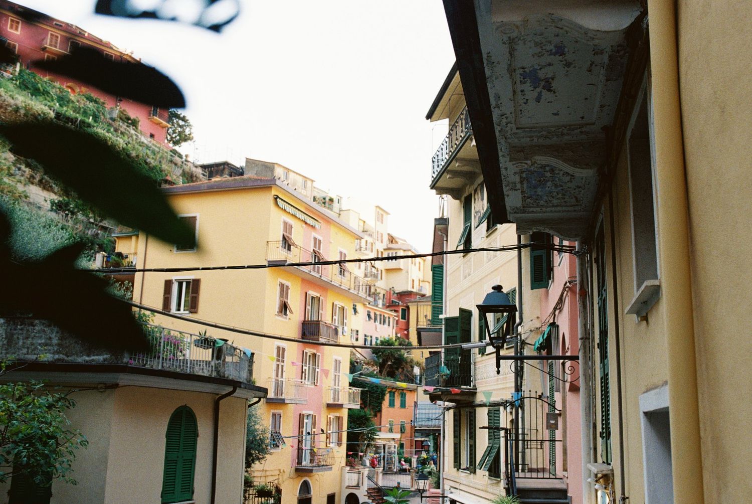 Colorful Italian coastal village street with traditional architecture and balconies.