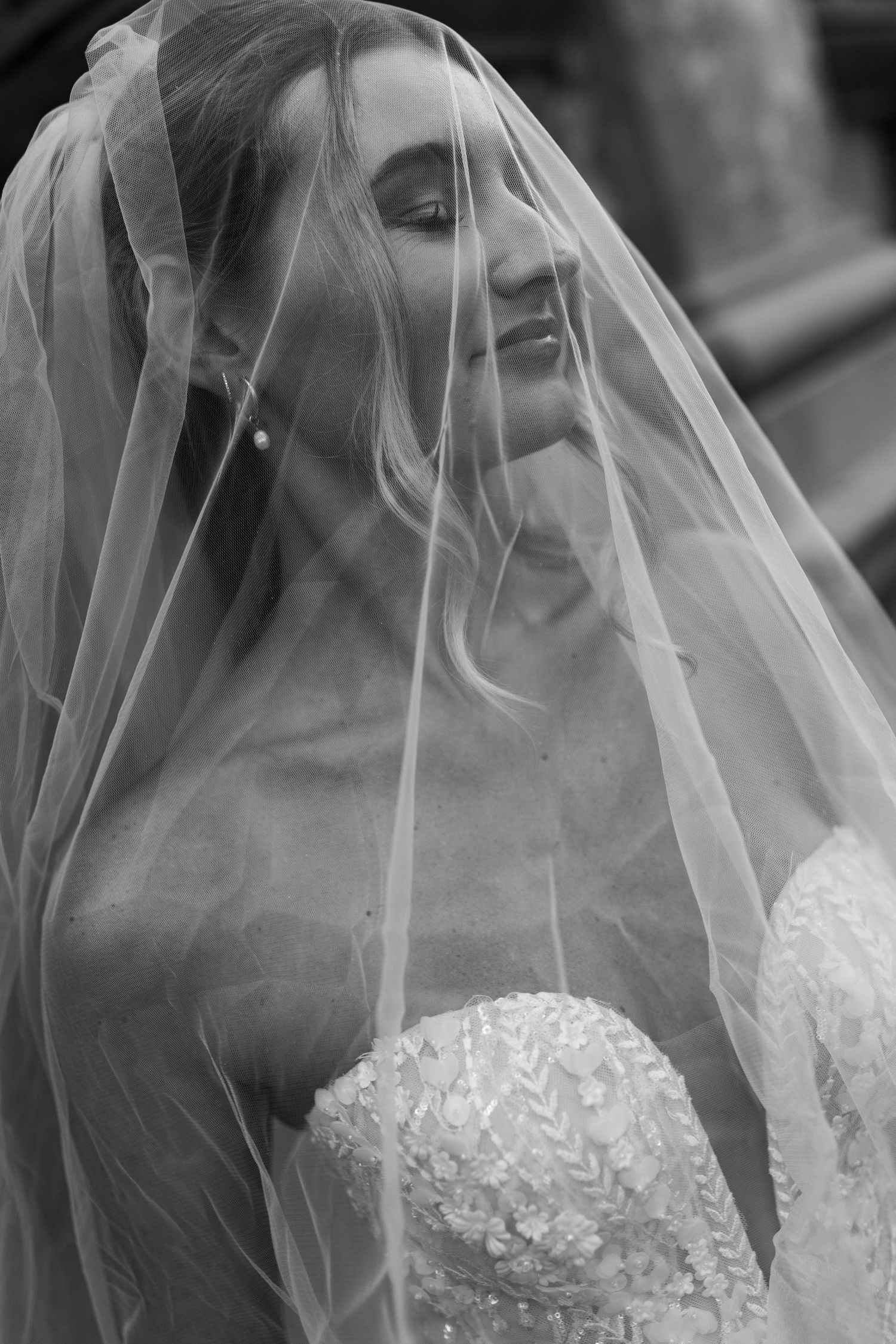 Artistic black and white close-up shots of bride wearing delicate tulle veil.