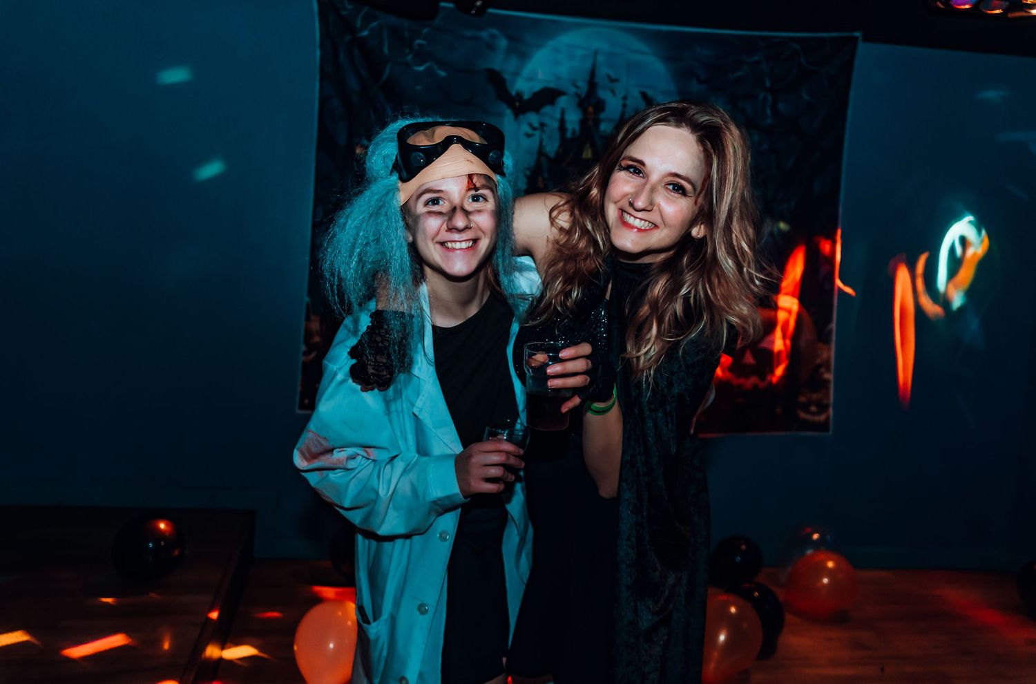 Friends enjoying a night out at a club with neon lighting and dark ambiance.