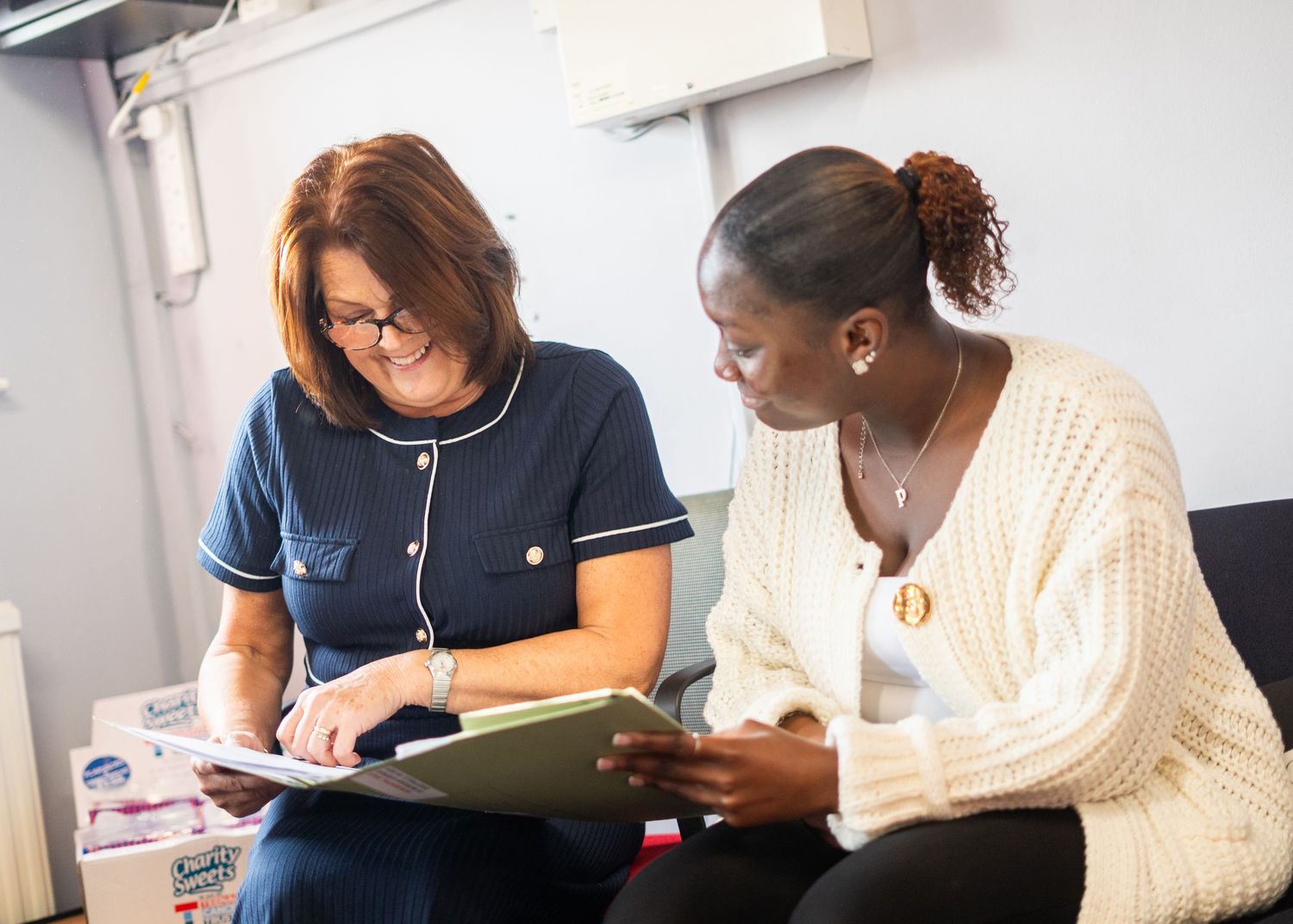Professional workspace showing people collaborating and reviewing documents.