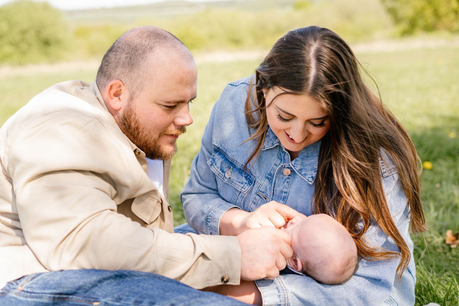 Family sharing joyful moment together during outdoor photo session in field.