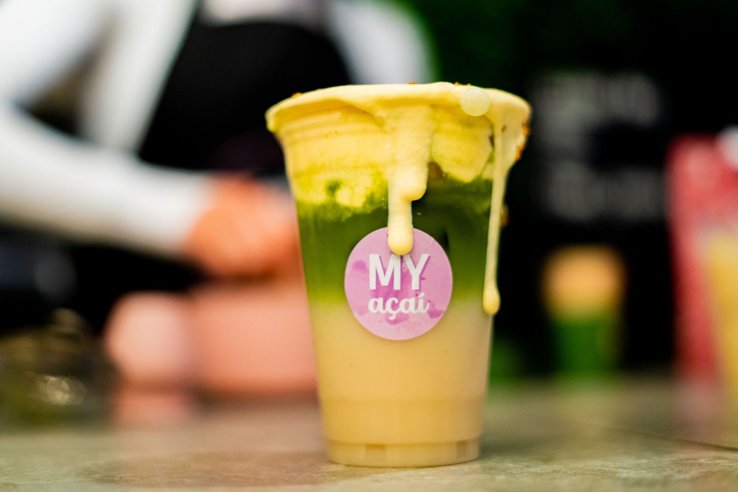 Assorted beverages in branded cups arranged on a cafe counter.