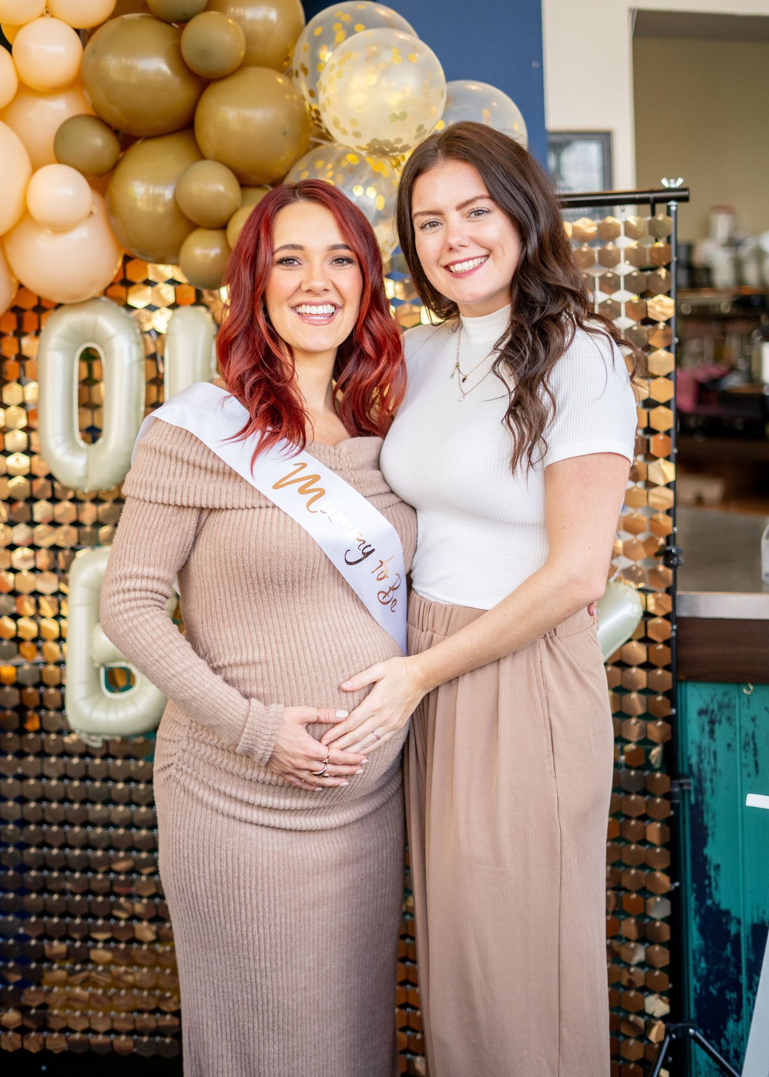 Friends in coordinated neutral outfits pose together at a decorated event space.
