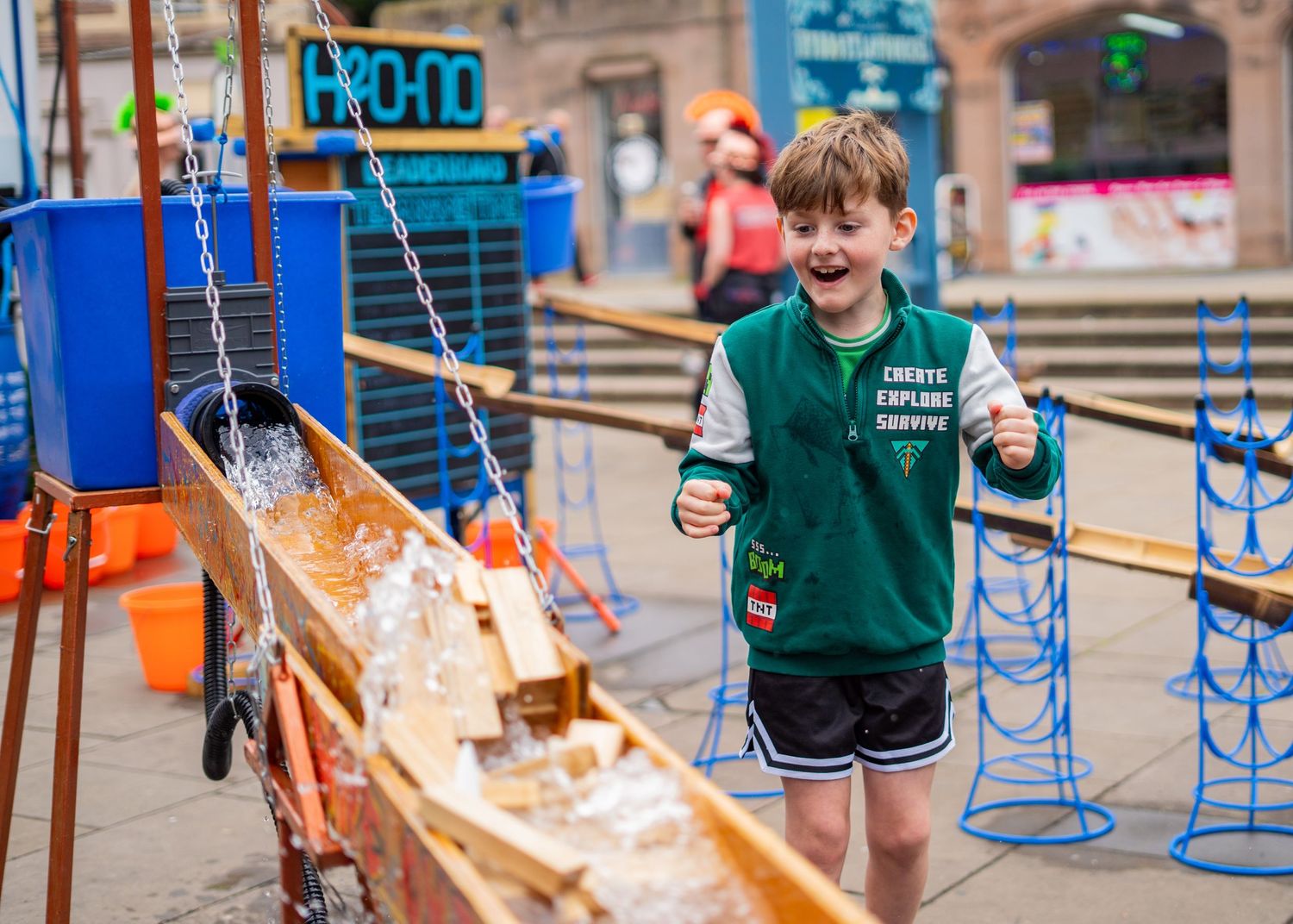 Children engaging with interactive water exhibits at an outdoor science museum.