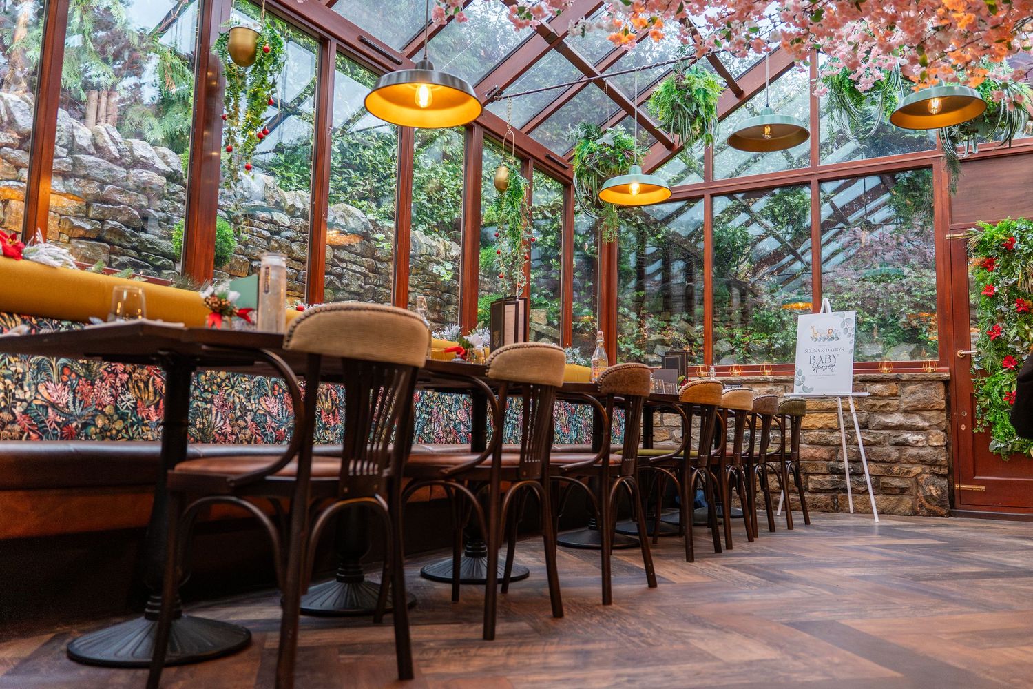 Rustic restaurant interior with wooden beams and yellow pendant lighting.