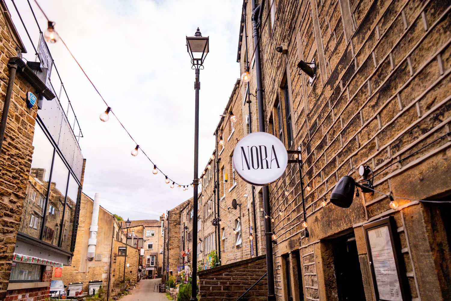 Charming cobblestone street lined with traditional stone buildings and vintage street lamps.