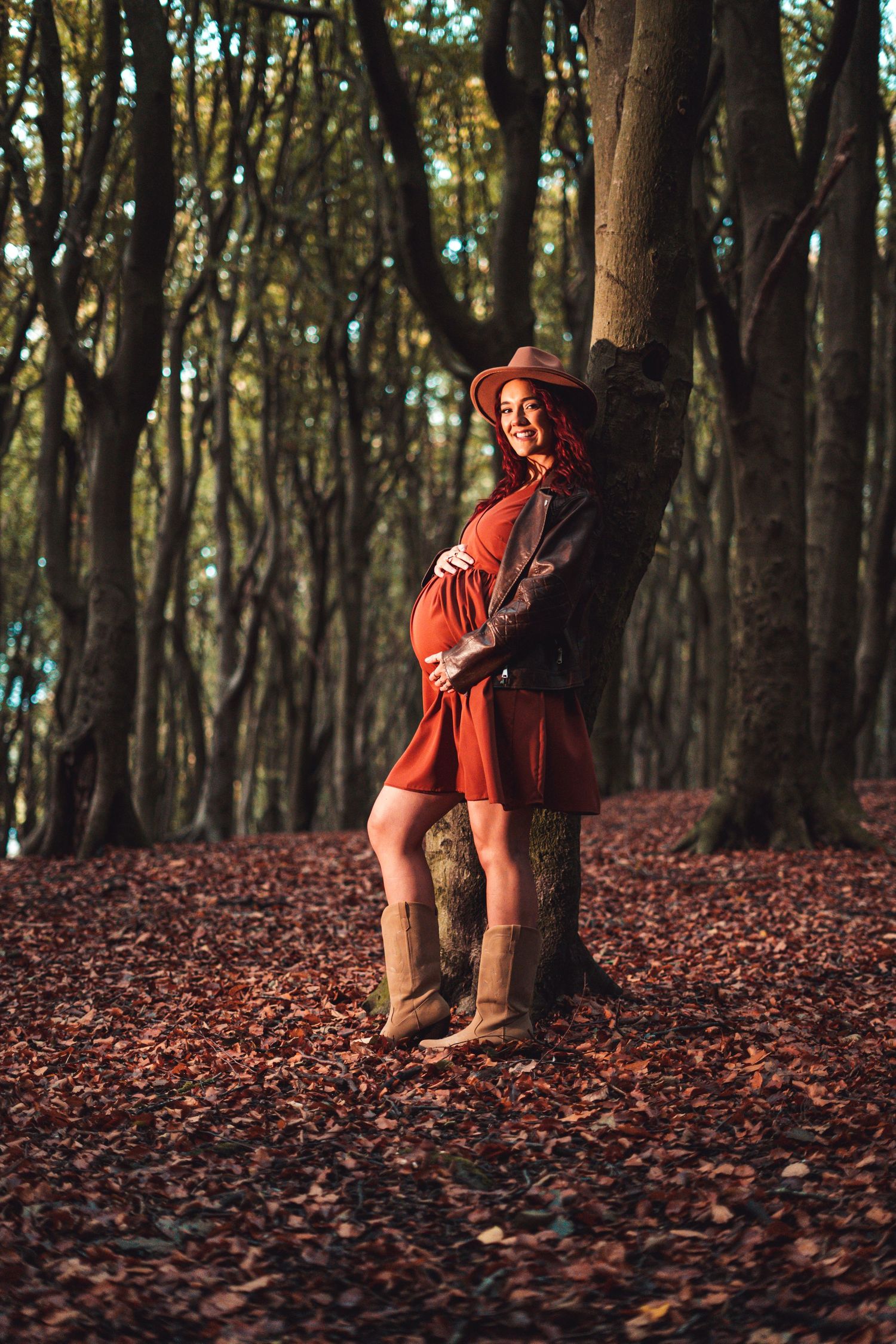 Artistic forest photography with a figure in red among fallen autumn leaves.