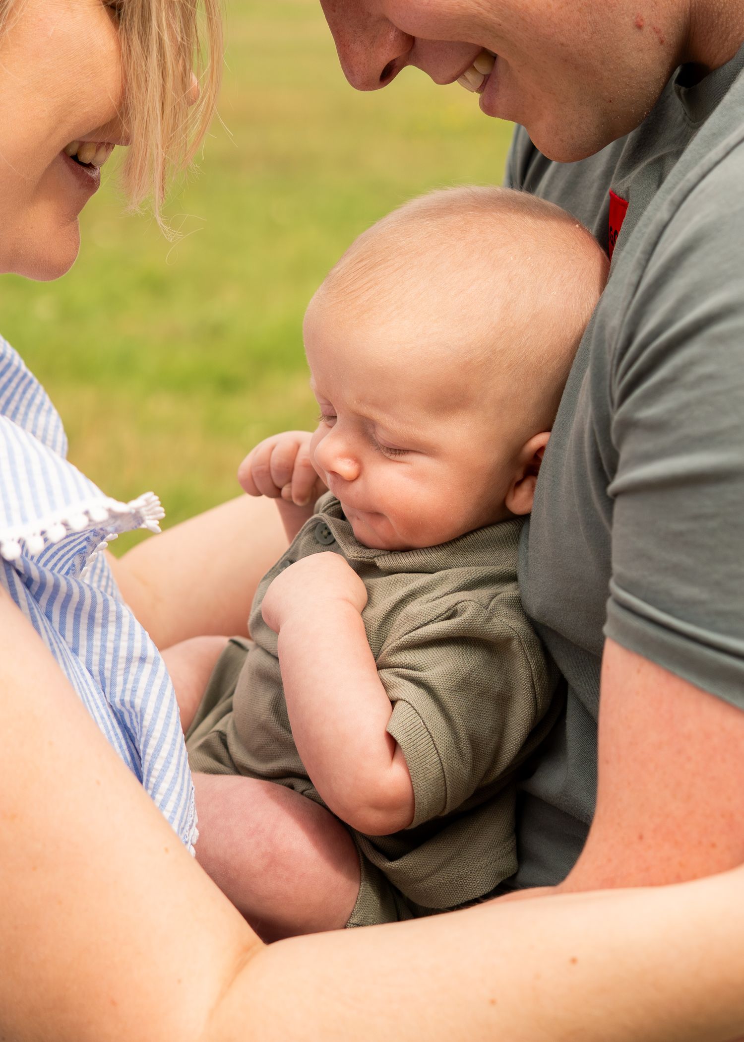 Intimate family moments captured in a sunny outdoor setting with natural expressions.