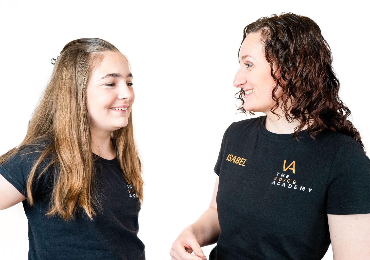 Students in black t-shirts share a joyful moment during a music lesson.