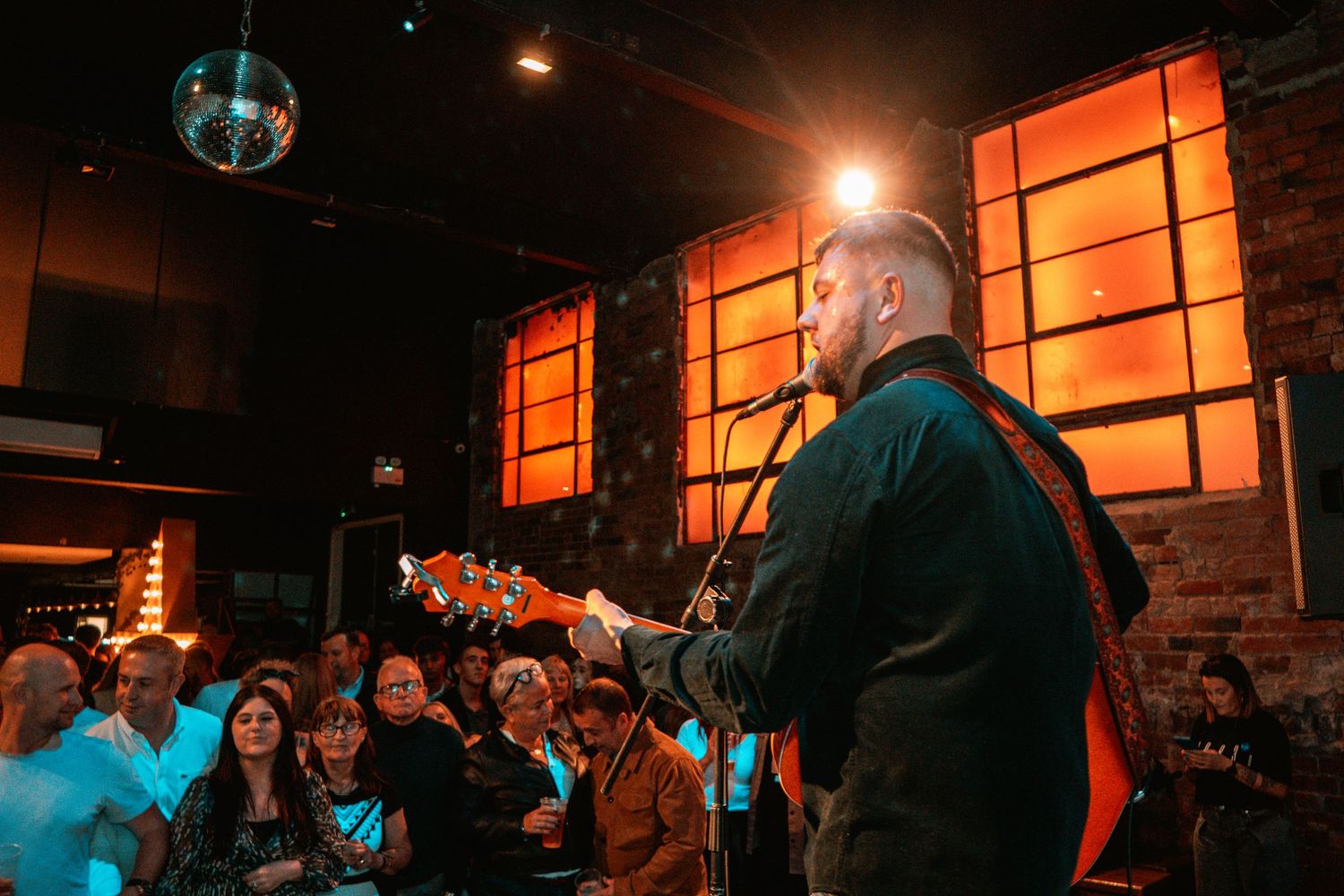 Atmospheric nightclub scene with orange lighting and disco ball creating a warm party ambiance.