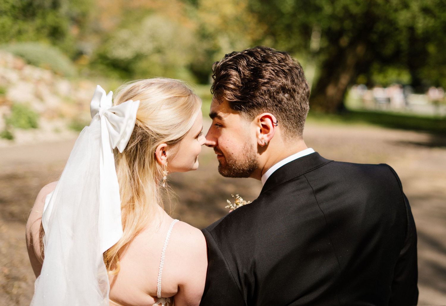 A romantic wedding moment captured outdoors in natural lighting.