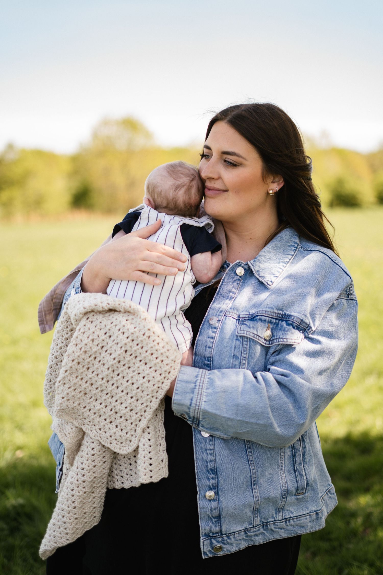 A series showing tender moments between a person and infant against a sunny outdoor backdrop.