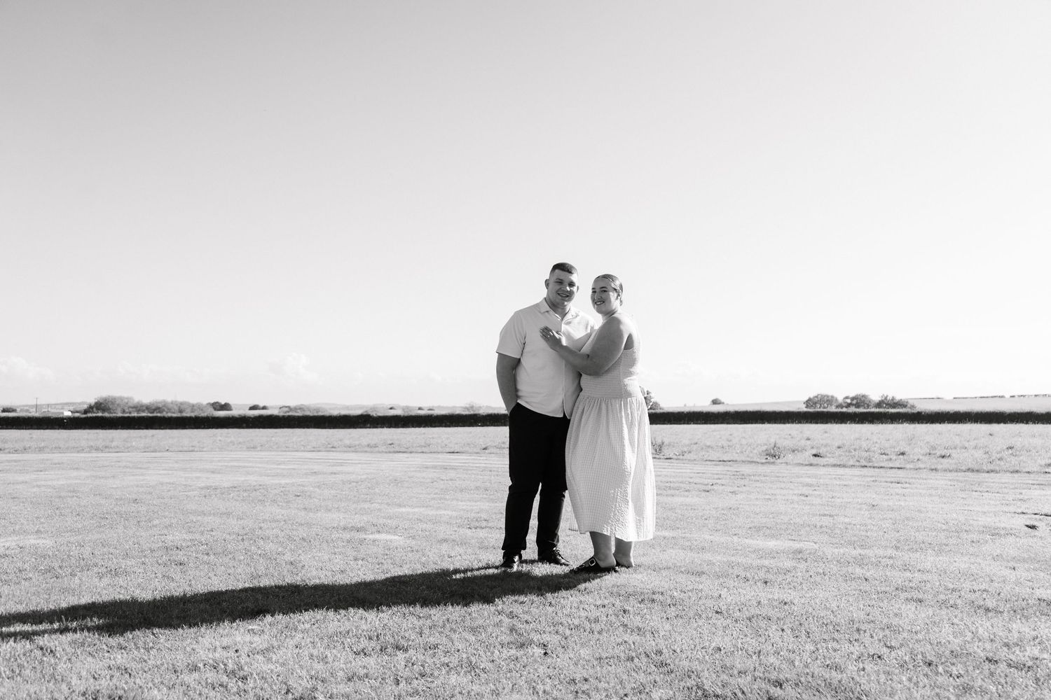 A romantic black and white beach engagement photo session at sunset.