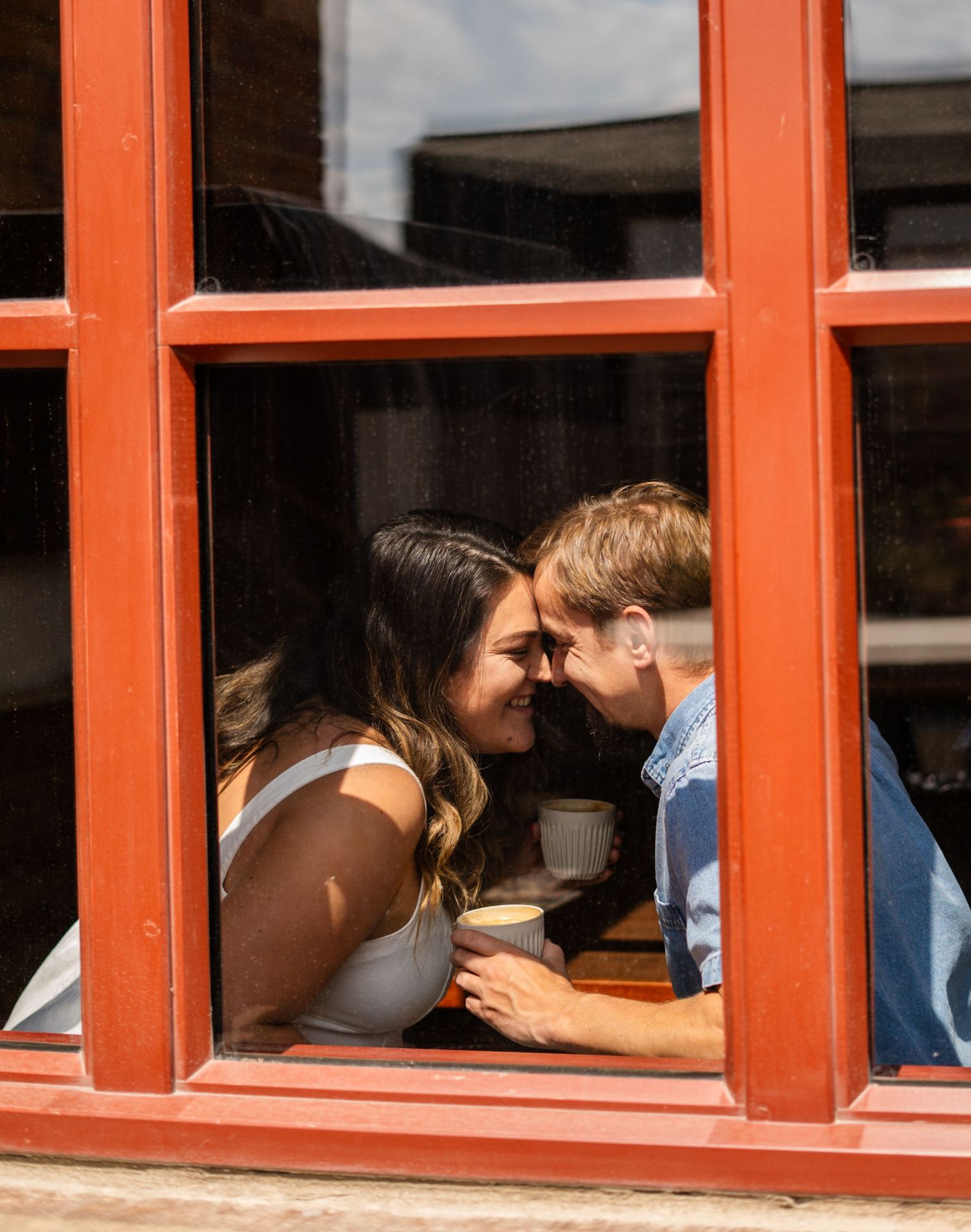 Three window panels show a couple sharing tender moments in orange frames.
