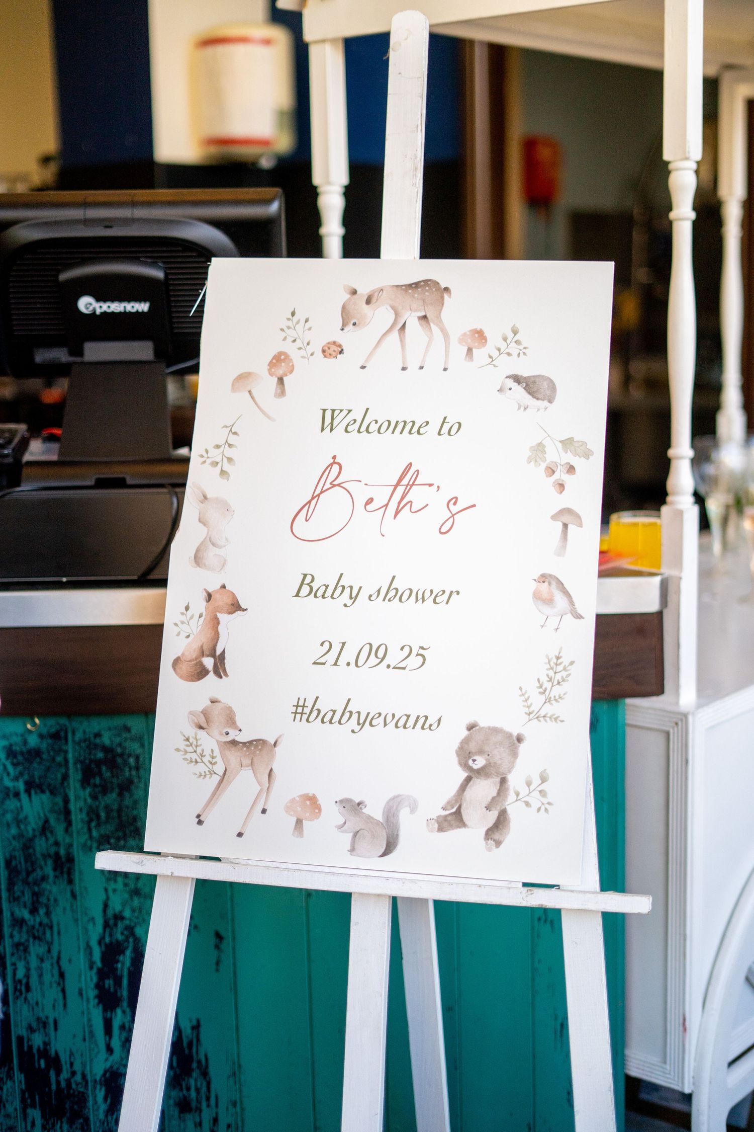 Welcome signs for a baby shower featuring woodland animal illustrations on white easels.