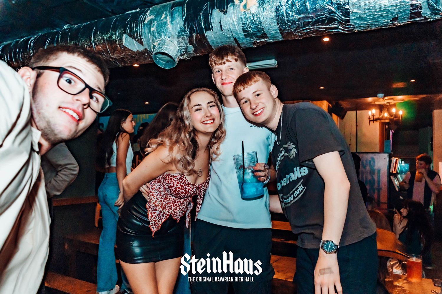 Late night party scene at Steinhaus with groups socializing and dancing.