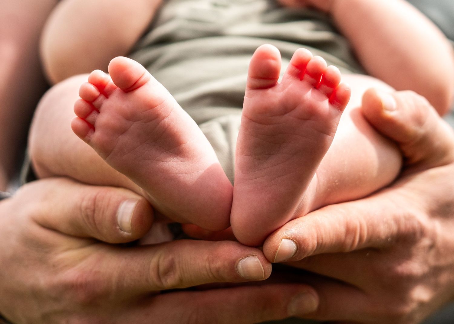 Series of close-up shots showing tiny baby feet against a blurred background.