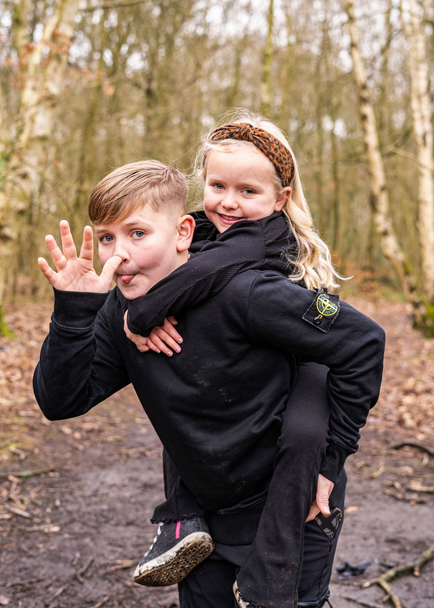 Energetic outdoor photography with people in black hoodies making silly poses.