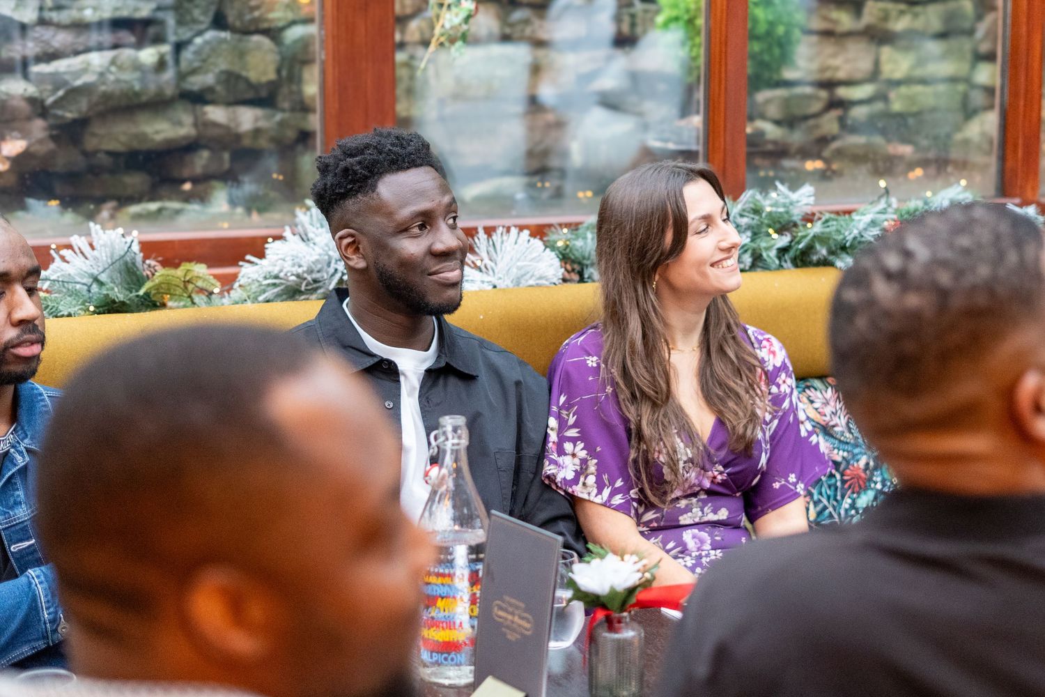 People gathered at tables for a celebratory event in a cozy indoor setting.