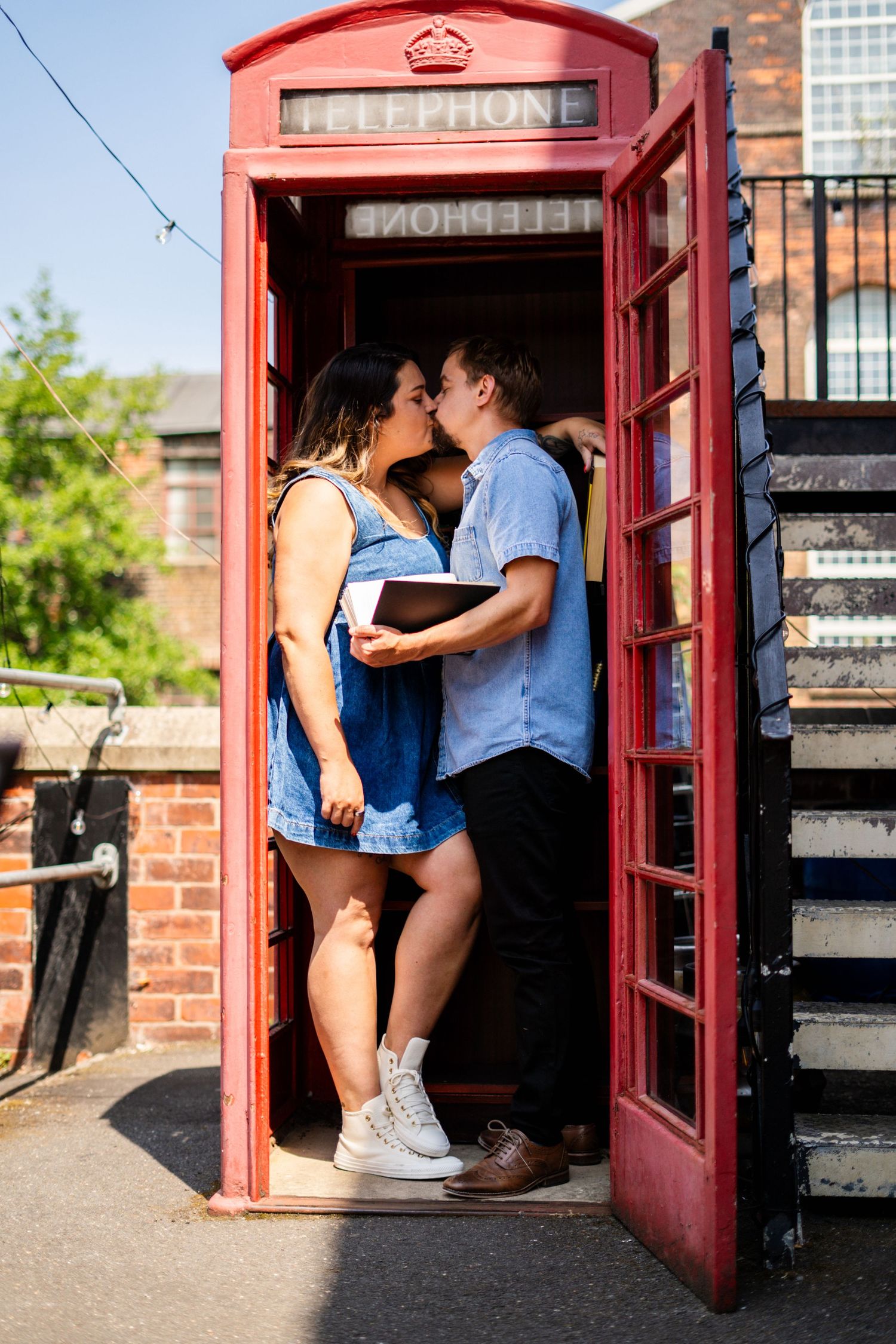 Candid photography series showing tender moments inside an iconic red telephone box.