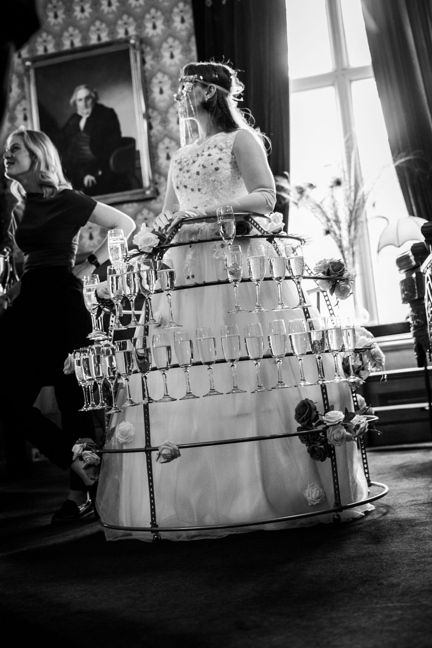 Unique wedding dress design featuring champagne glass holders in a tiered skirt structure.