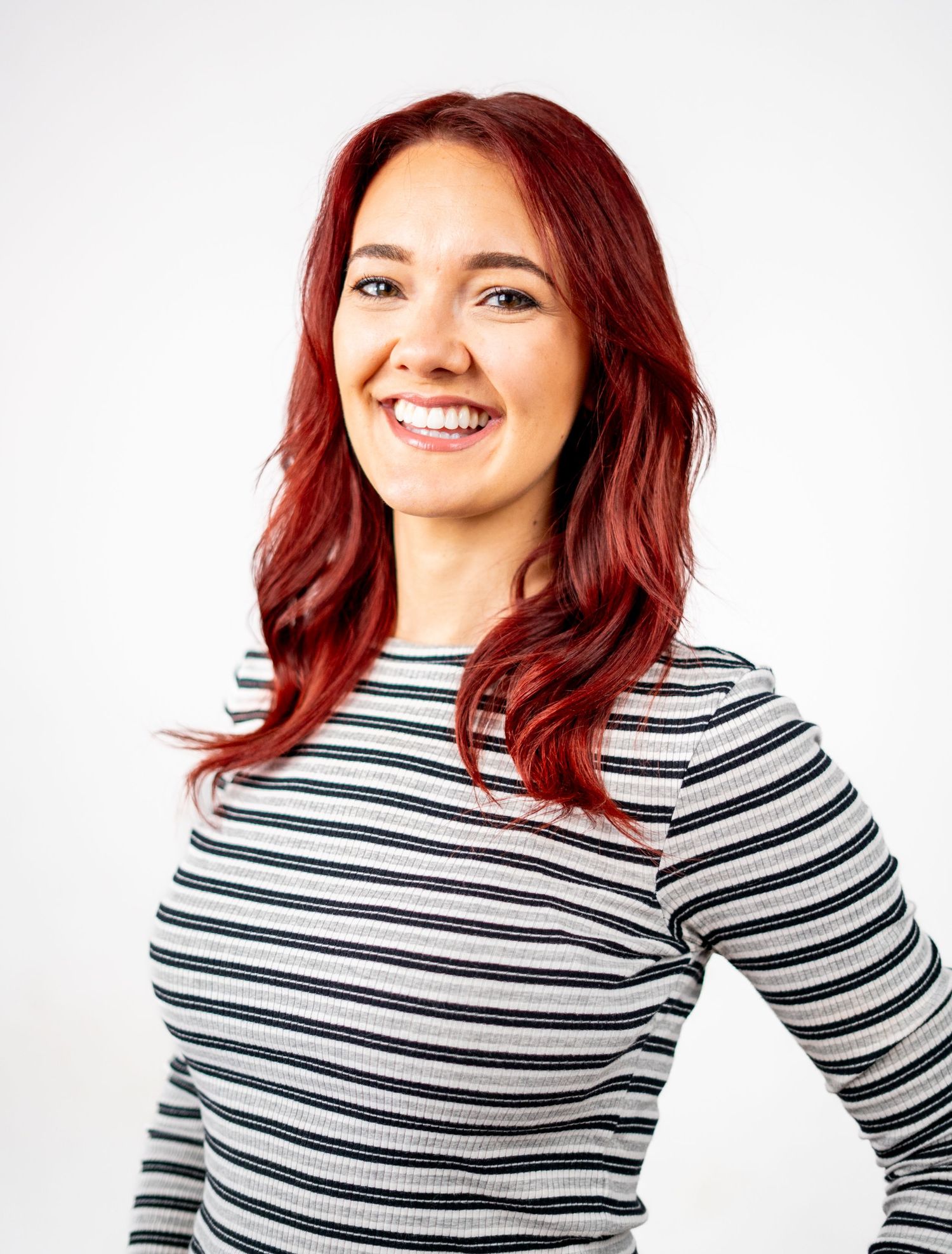 Studio portraits featuring bright red hair and striped top against white background.