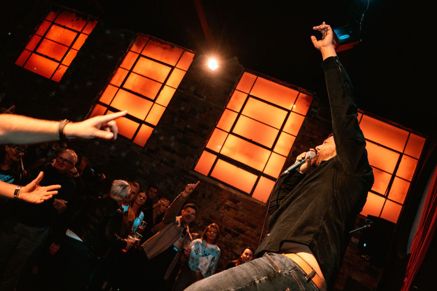Stage performance with orange backlit panels creating dramatic lighting effects.