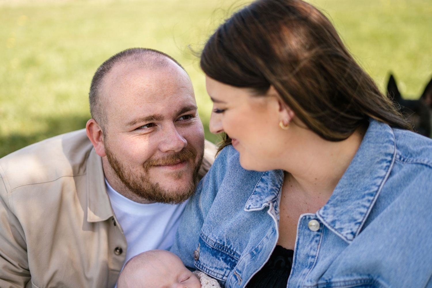 Intimate outdoor family portrait featuring denim jackets and joyful expressions.