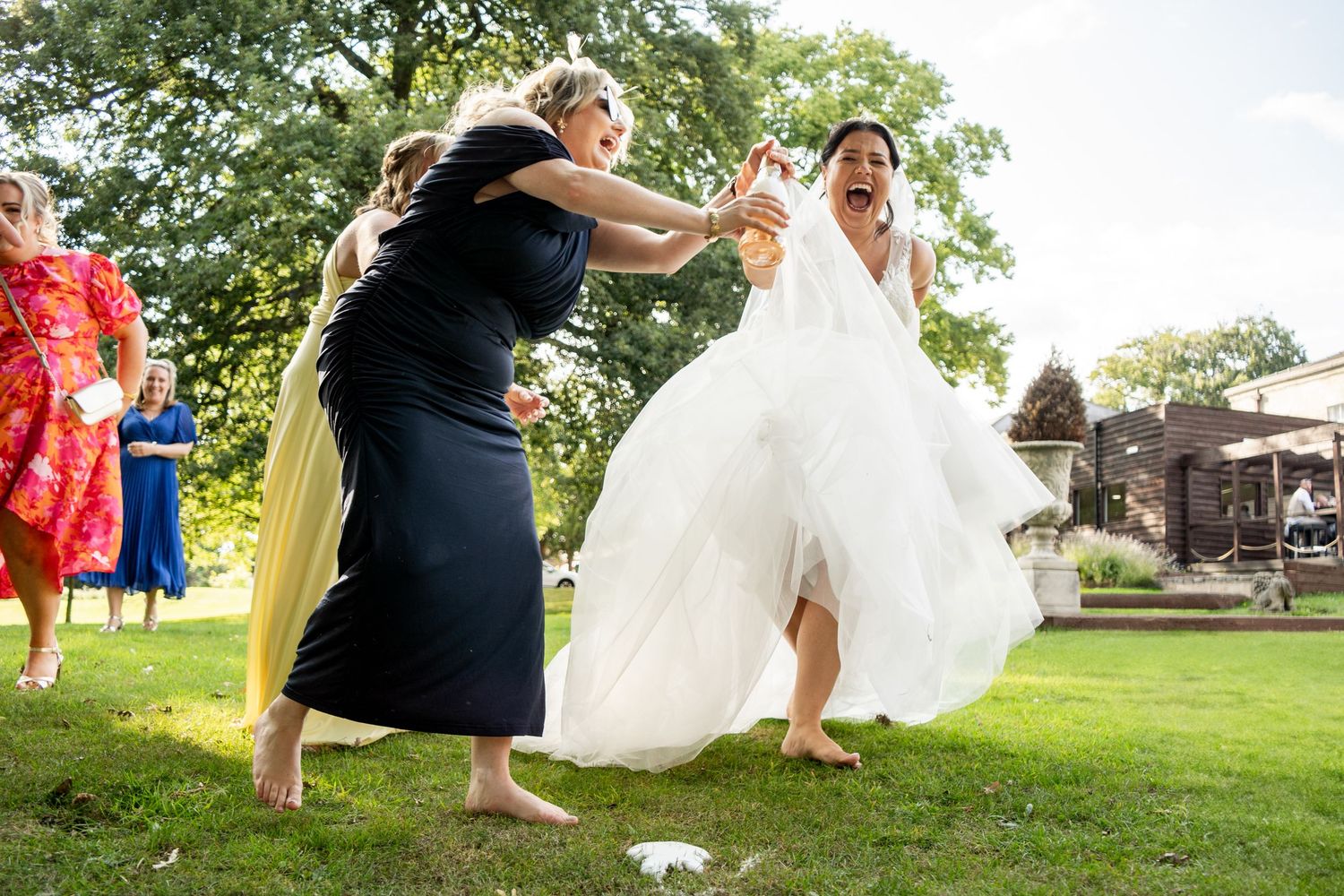 Playful outdoor wedding photography session on green lawn.