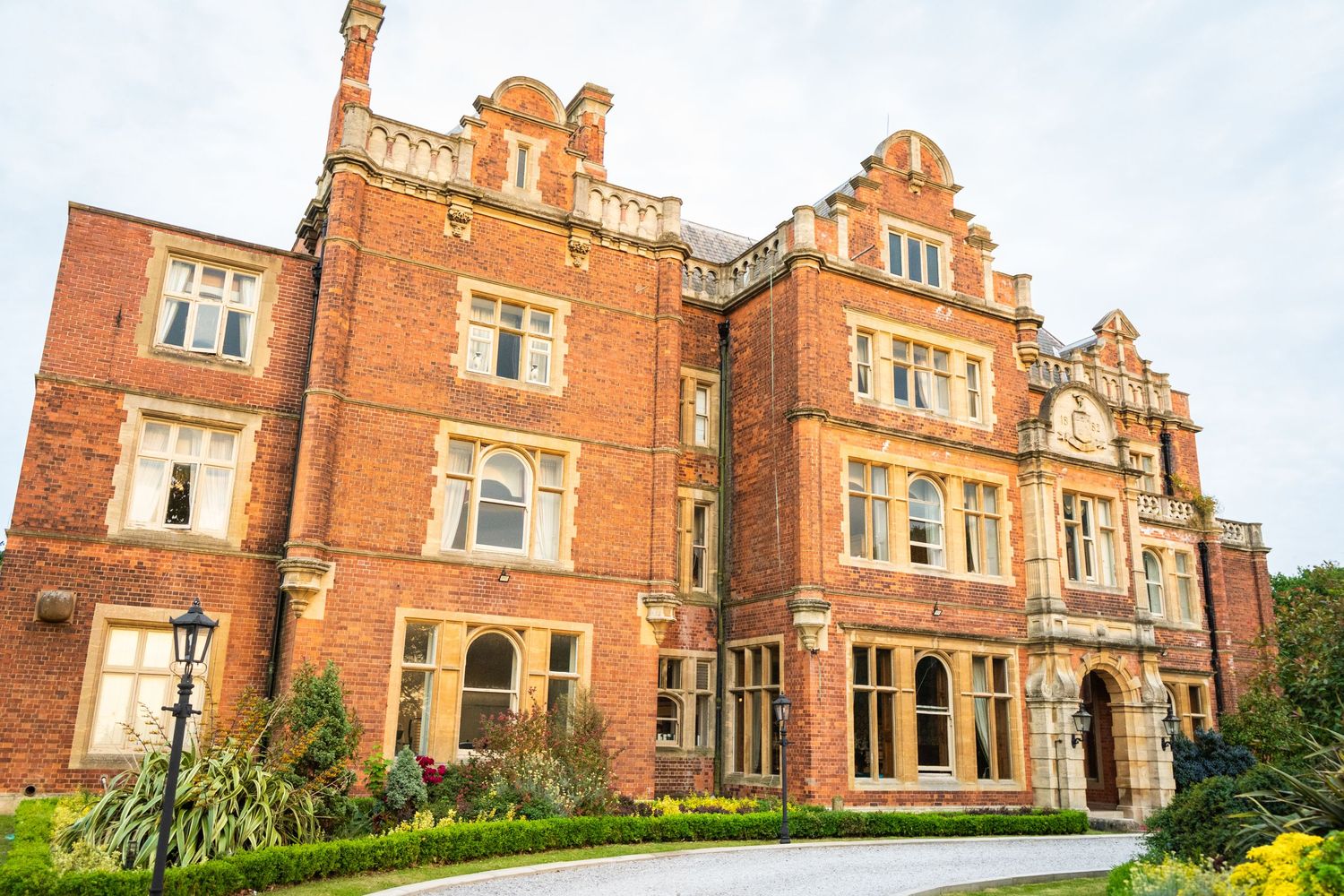 Grand Victorian red brick mansion with ornate architectural details and multiple stories.