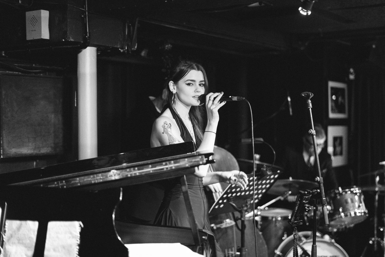 Black and white photo of musicians performing on stage with professional lighting setup.