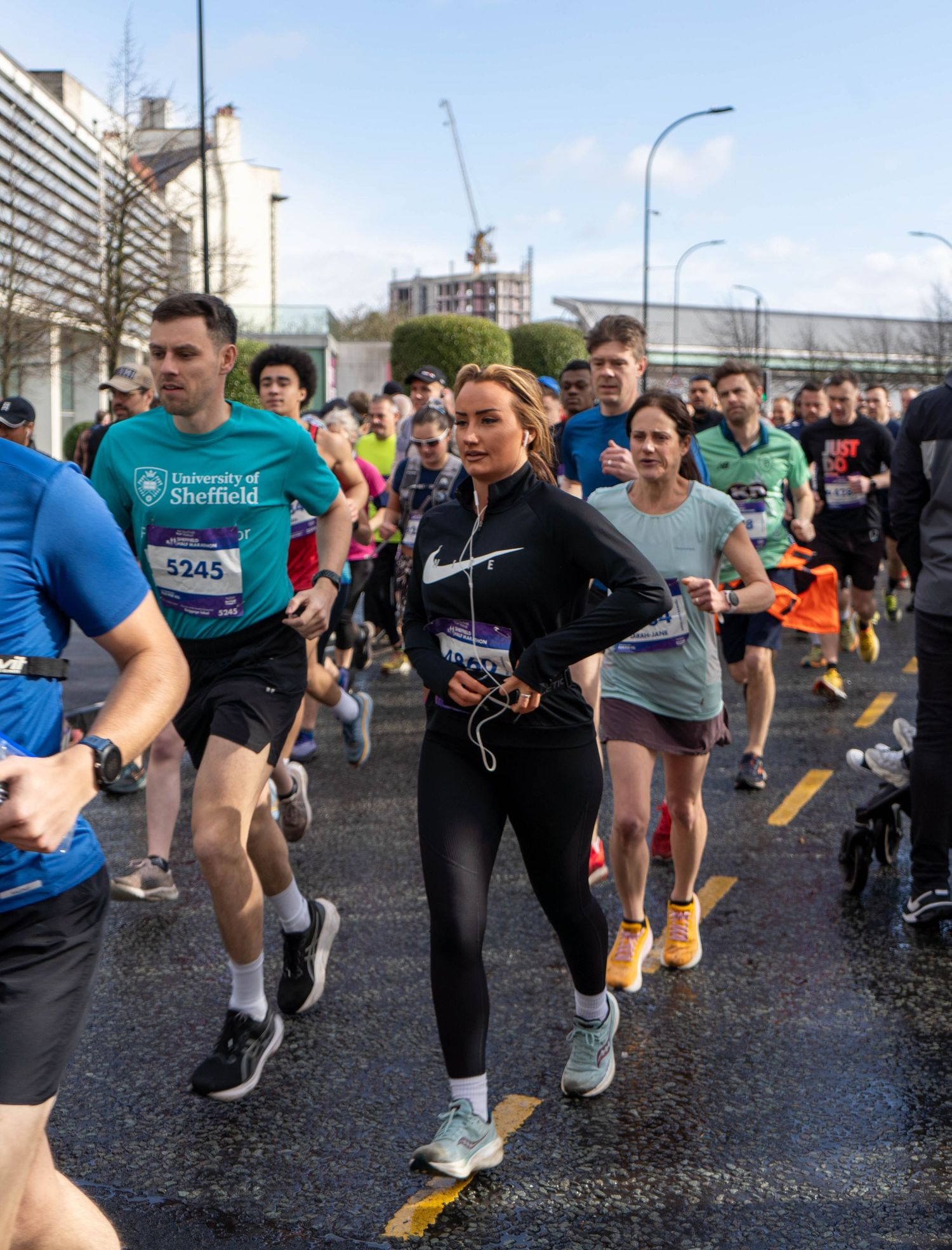 Runners warming up and stretching before a race on an urban street.