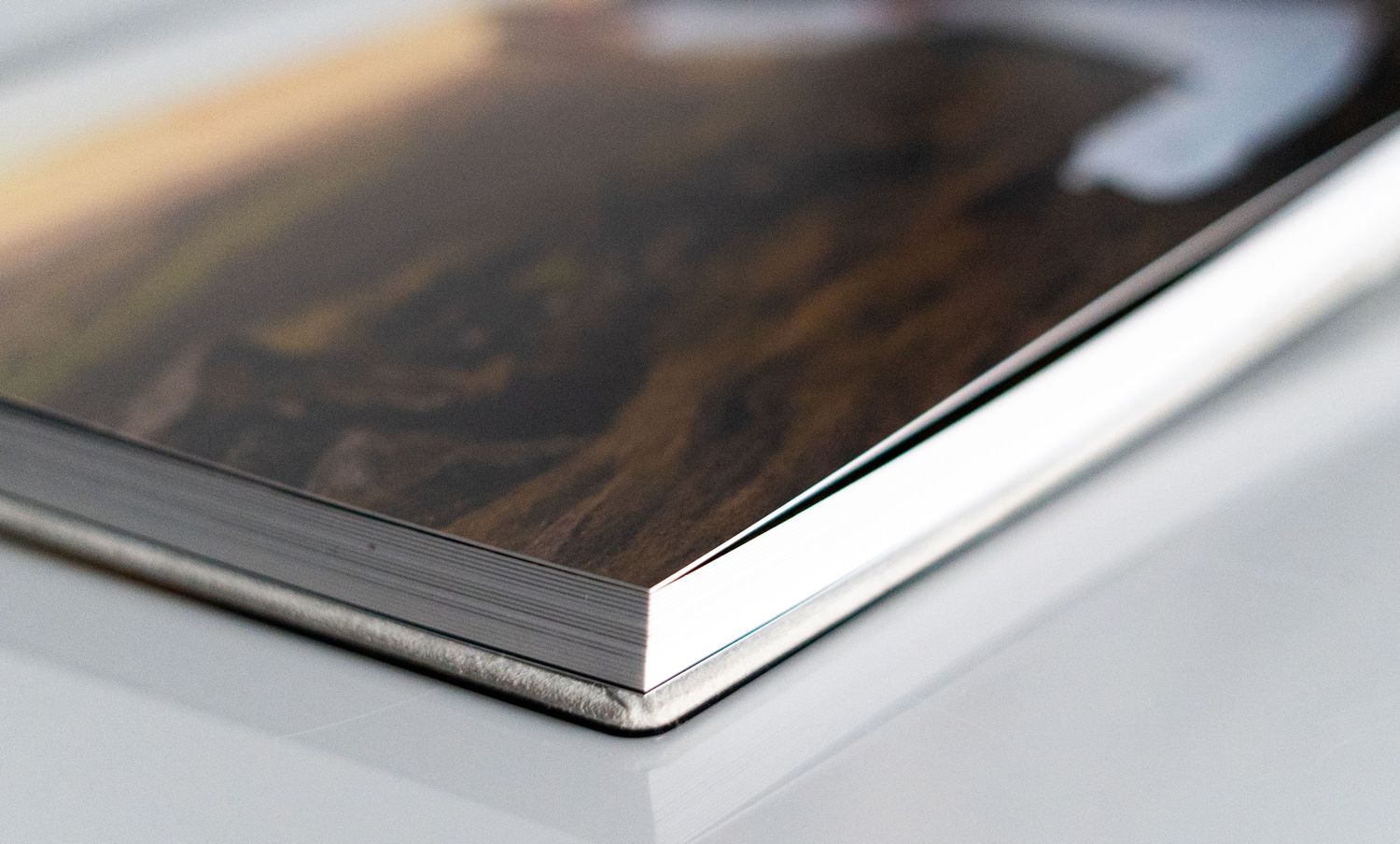 Close-up detail of a photo album corner showing premium metallic binding and finish.