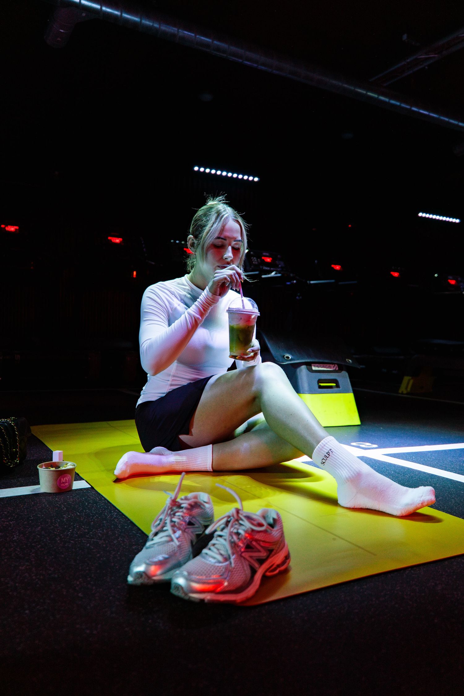 Dramatic low-light photo sequence of someone sitting on a yellow surface in athletic wear.