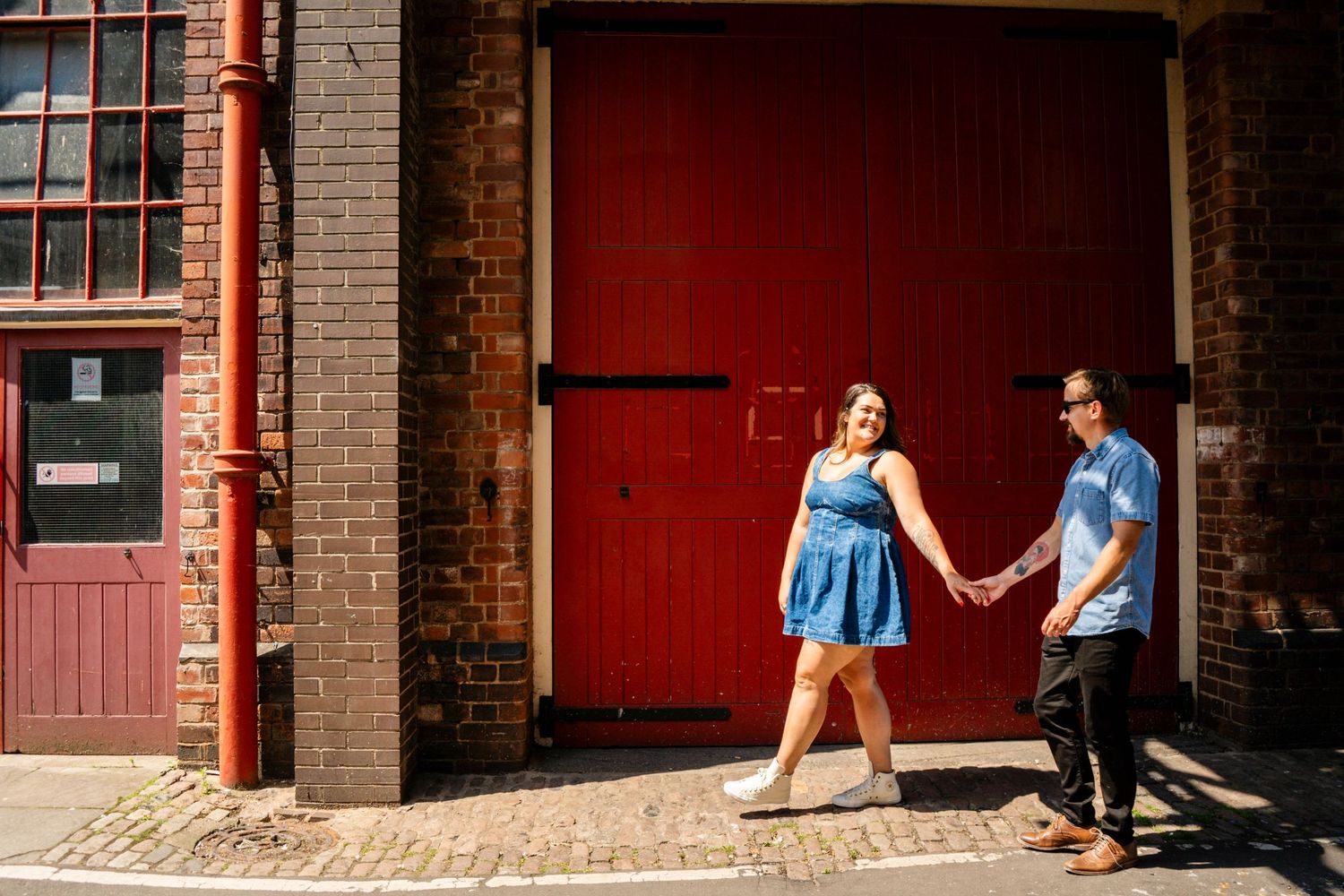 A series of romantic poses captured against red brick walls and doors.