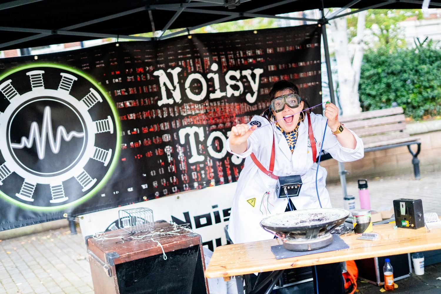 DJ equipment and music setup at an outdoor event with branded signage.