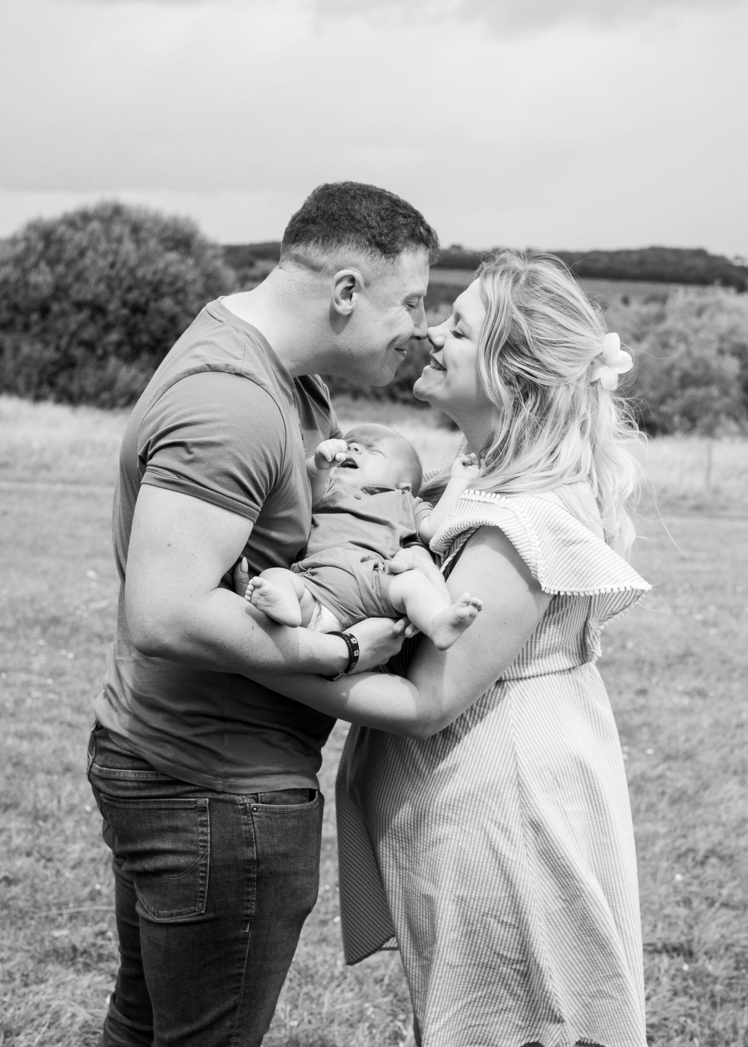 Family embracing together in natural outdoor setting.