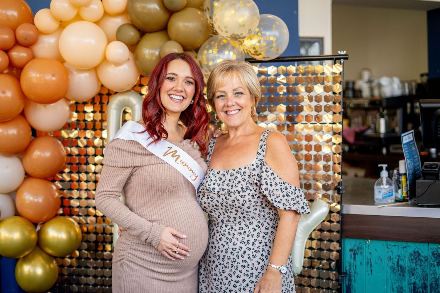 Party scene with decorative balloon display and friends sharing emotional moments together.
