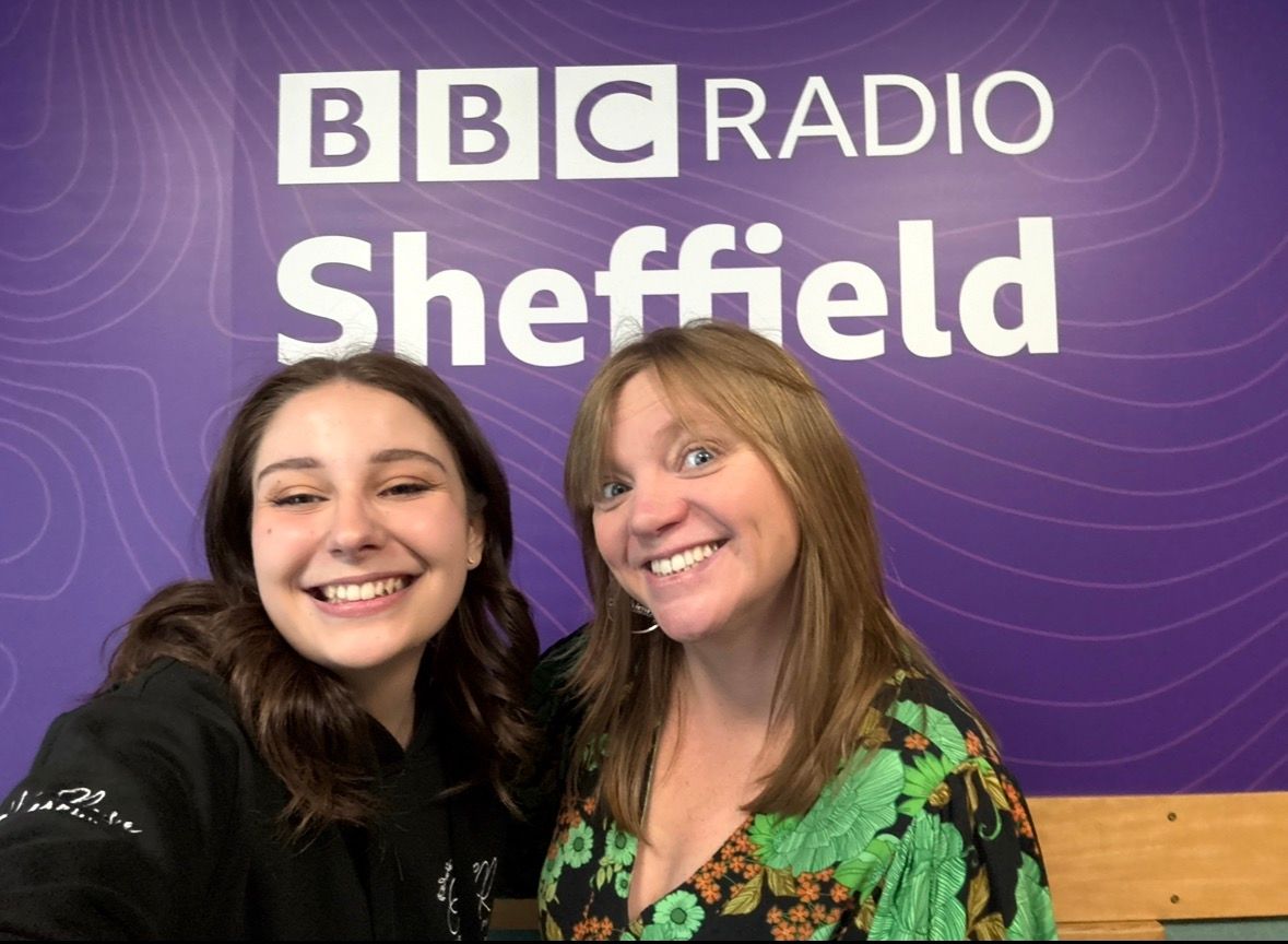 Two people posing in front of BBC Radio Sheffield purple backdrop.