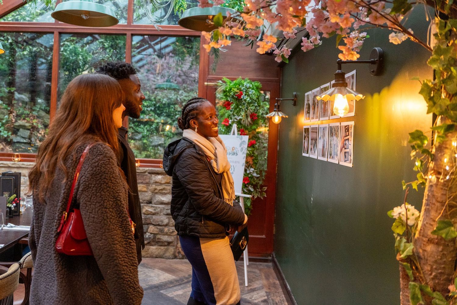 Guests mingling at an evening party with warm lighting and autumn decorations.