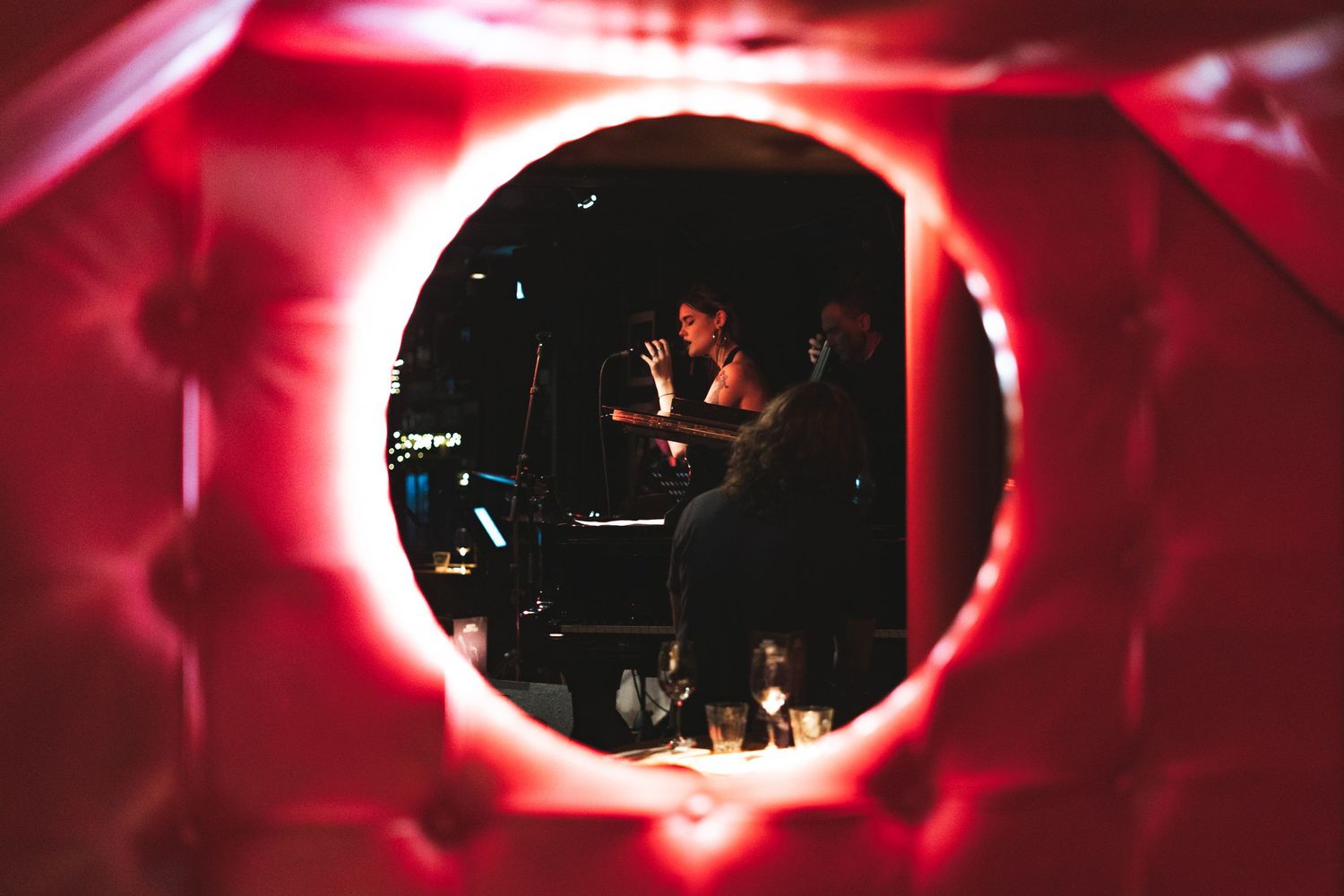 Artistic red eclipse lighting effect creating moody ambiance at concert venue.