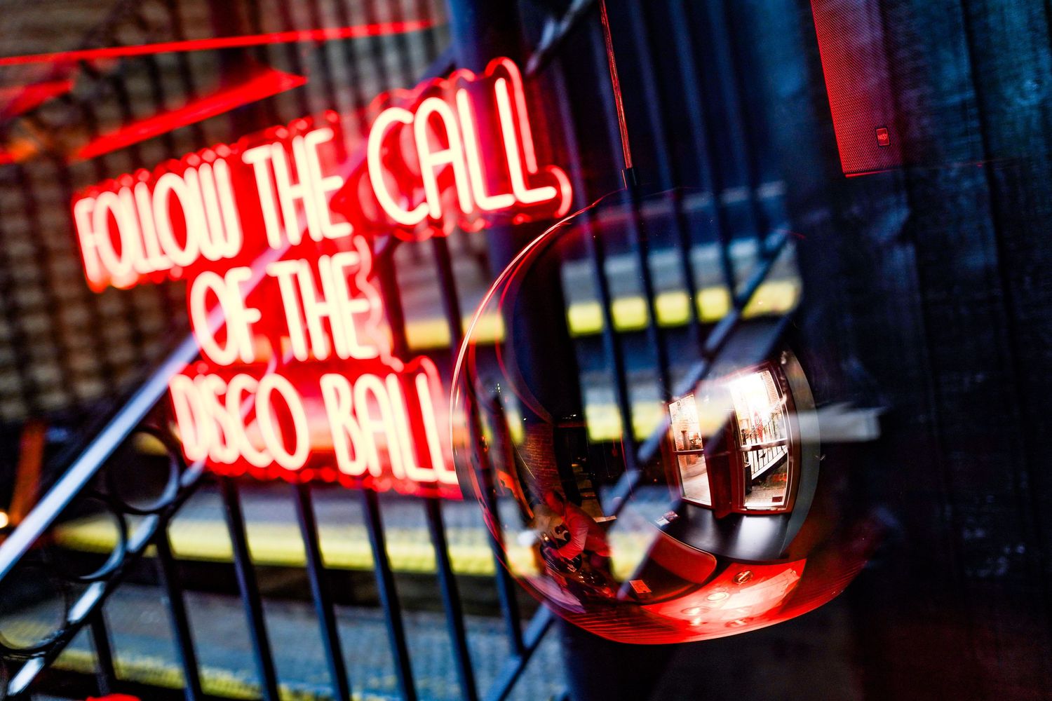 Red neon sign illuminating a dark interior space with artistic lighting effects.