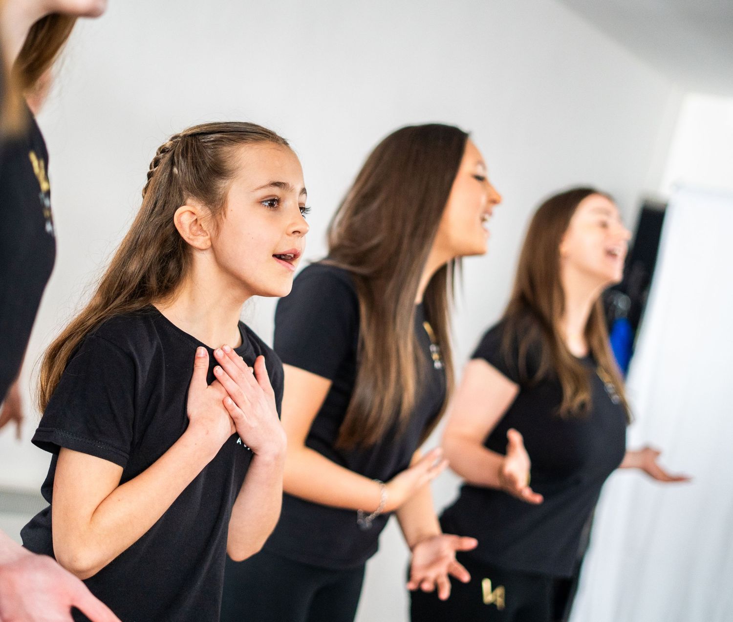 Students practicing vocal techniques in formation during group lesson.