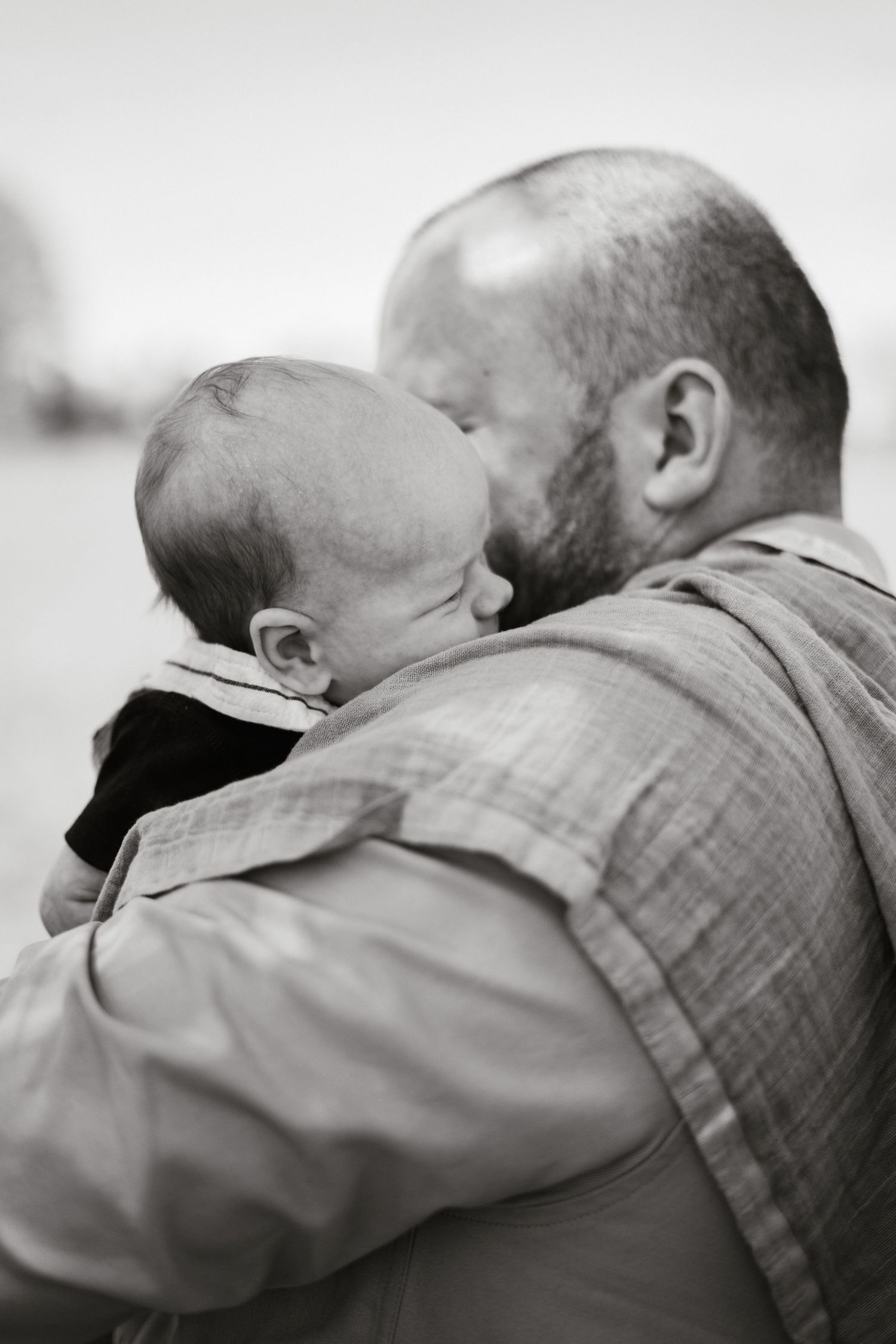 Black and white portrait of tender moment between parent and infant.