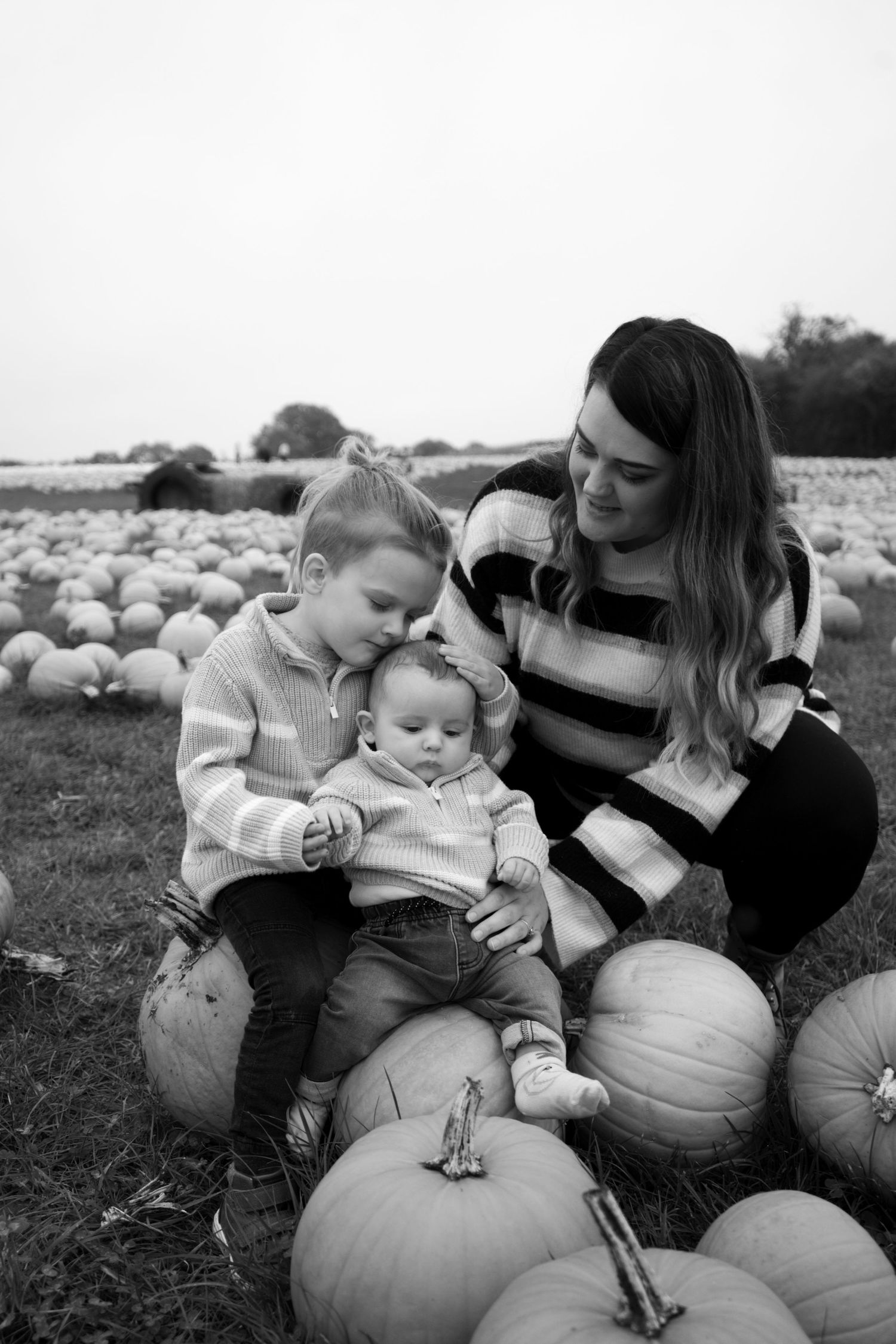 Black and white portraits captured at a pumpkin patch during fall season.