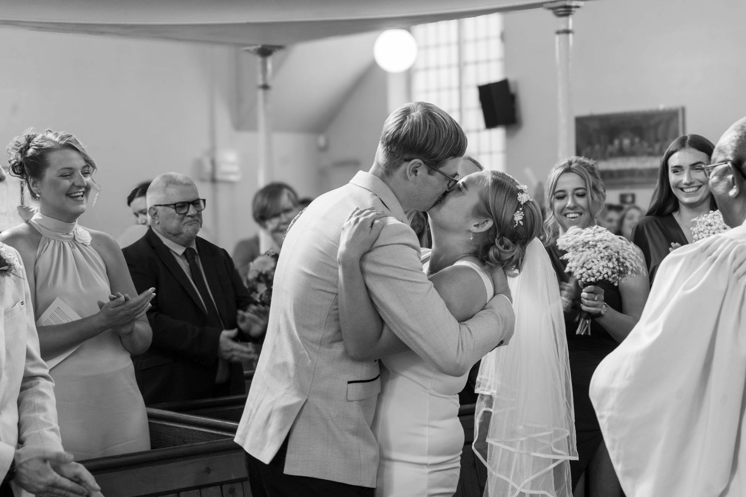 Wedding celebration candid moments captured in black and white at an indoor venue.