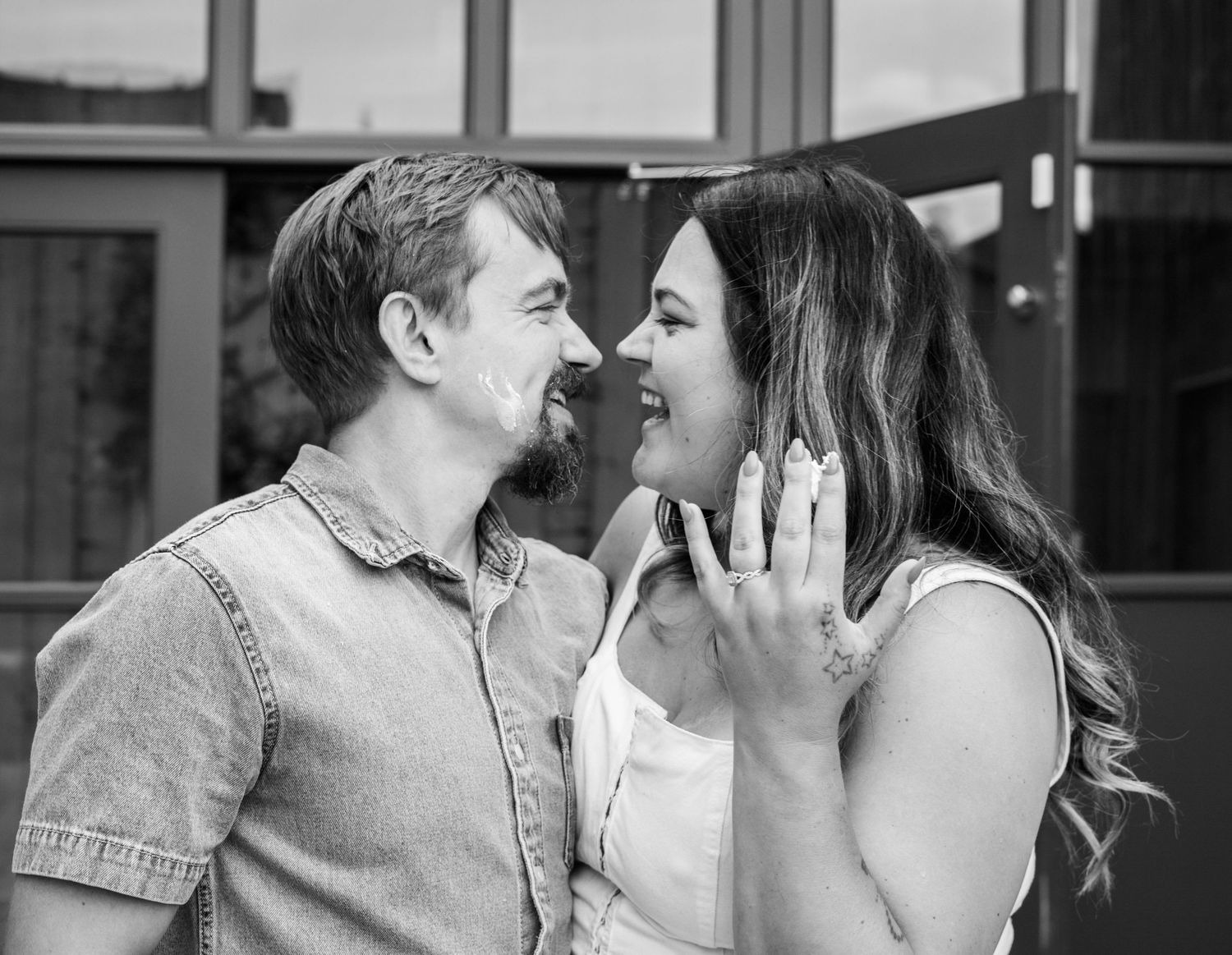 A couple sharing tender kisses in black and white photography.