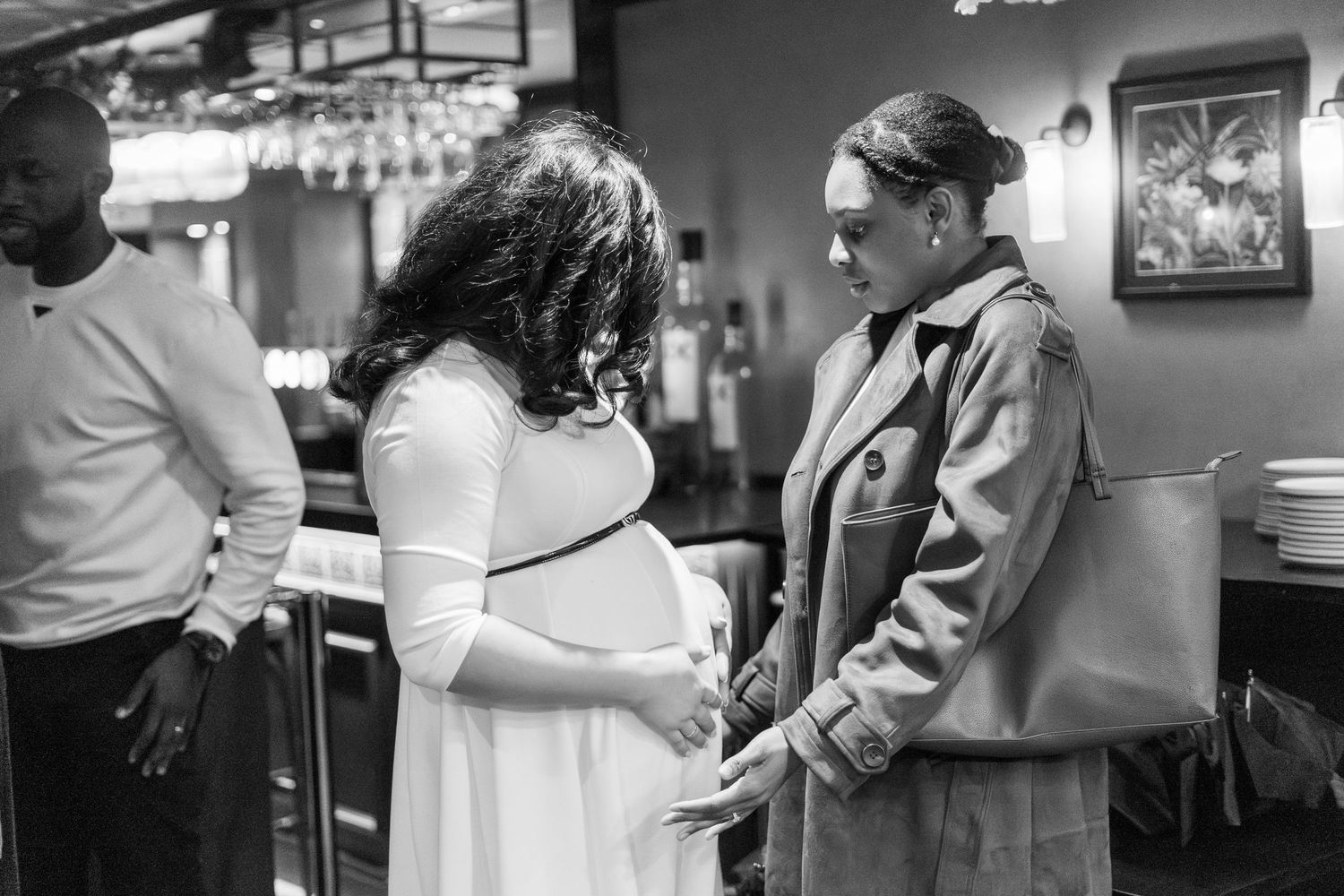 Black and white photo of people interacting at a social gathering.