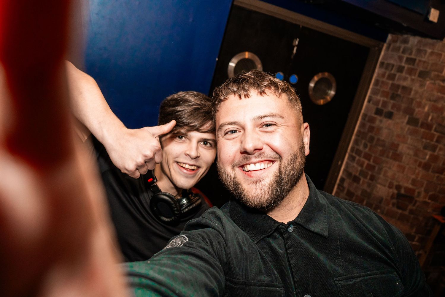 Friends taking a close-up selfie together at a nighttime venue.