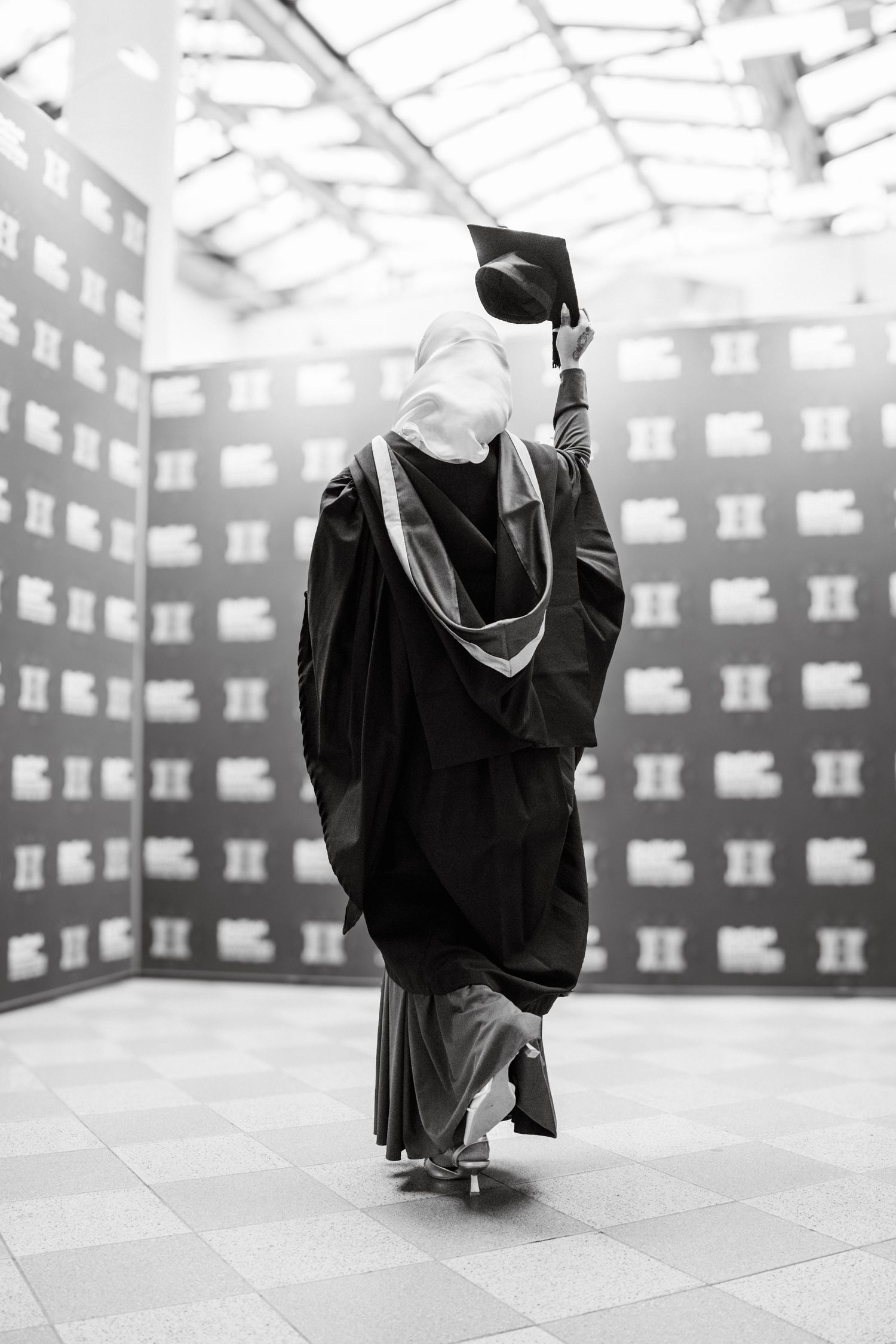 A sequence of black and white graduation photos showing academic robes against a geometric background.